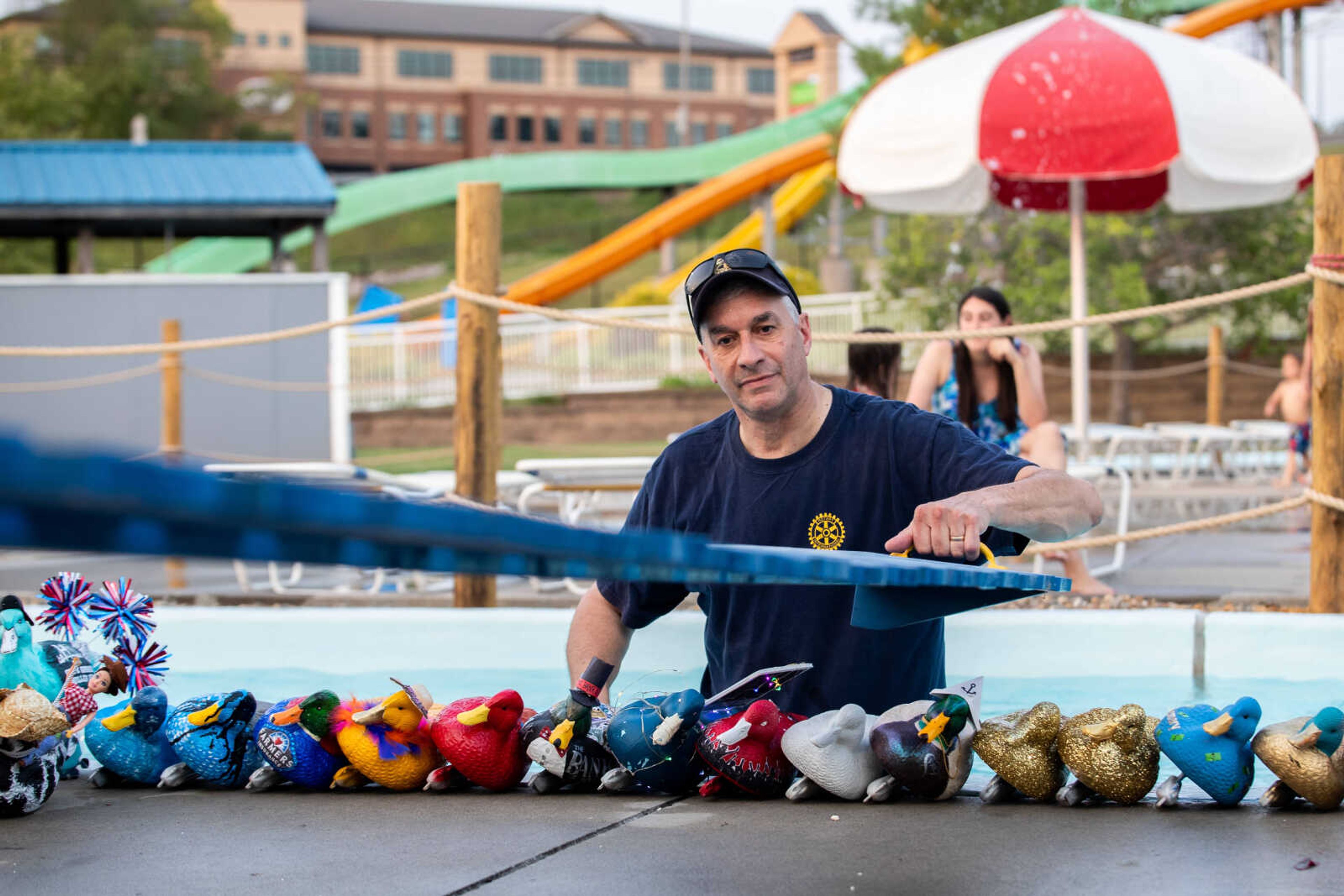 Scott McClanahan lifts a wooden board as he prepares for the corporate duck race at the 9th annual Duck Regatta on&nbsp;on Saturday, July 15 at Cape Splash.