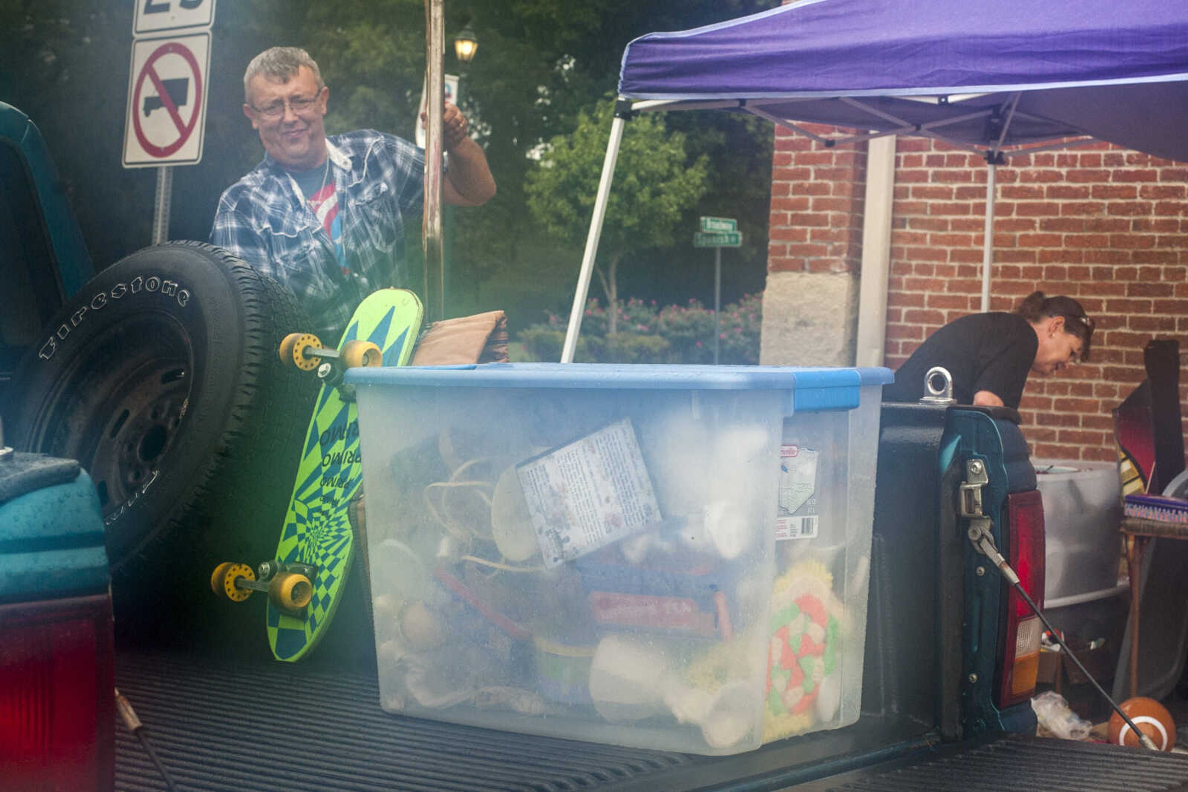 John Rogers, left, loads items into a truck as his wife, Susan Rogers, dries their inventory Sunday, Oct. 6, 2019, at the Cape Girardeau Downtown Tailgate Flea Market. It was the Gordonville couple's fourth time working as vendors at the semi-annual flea market. "We tried sticking it out, but everybody left on us," John said with a laugh.