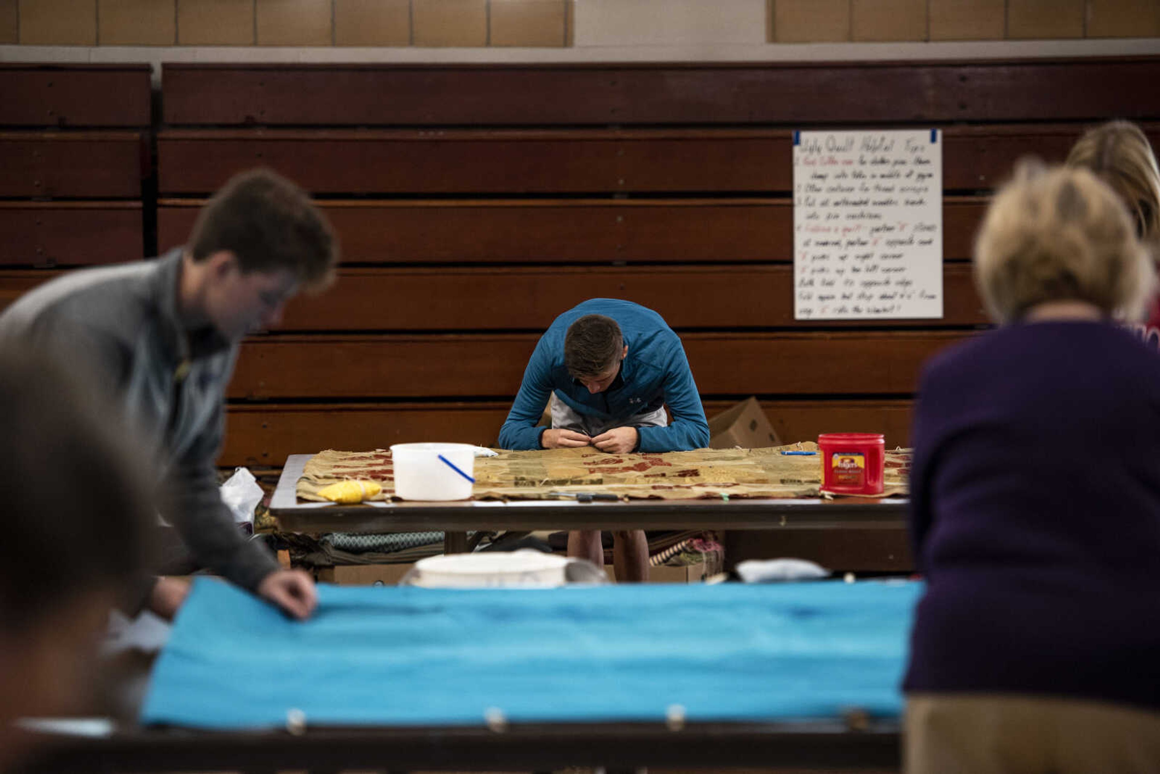 Cole Bruenderman, back center, tacks a quilt during the Ugly Quilt Weekend at St. Vincent de Paul Parish Sunday, Oct. 28, 2018, in Cape Girardeau.