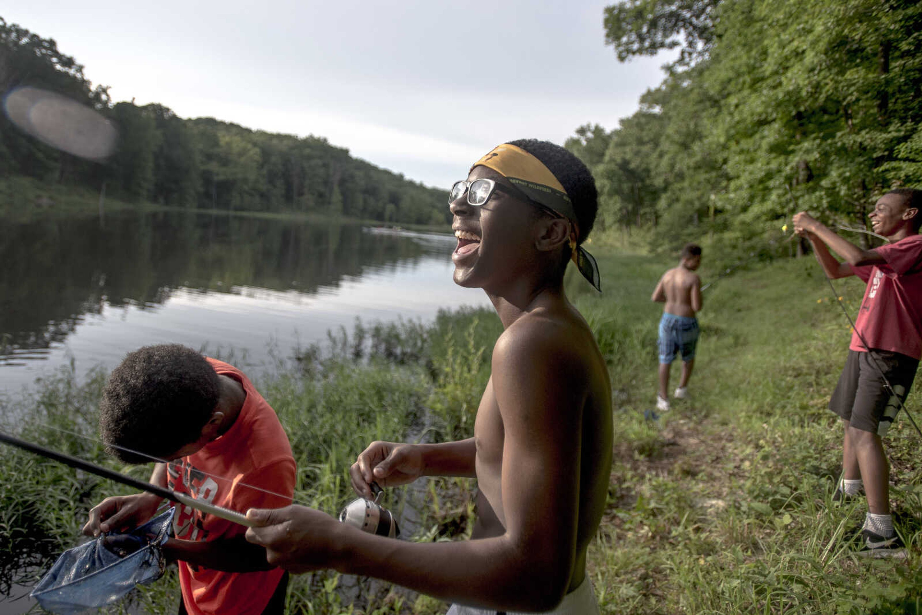 Jimini Smoot, center, laughs while fishing with Jeremiah Twiggs, left, Malachi Smoot, background, and Warren Eanes, far right, on a lake Thursday, June 27, 2019,&nbsp;near the Castor River in Bollinger County.&nbsp;The boys are members of the Honorable Young Men Club, a mentorship program started by former Southeast Missouri State University football players that partners with the Cape Girardeau school district to provide at-risk students with guidance and positive role models. The club camping trip was in part intended to help foster an appreciation for nature in the boys, some of whom hadn't been camping before.