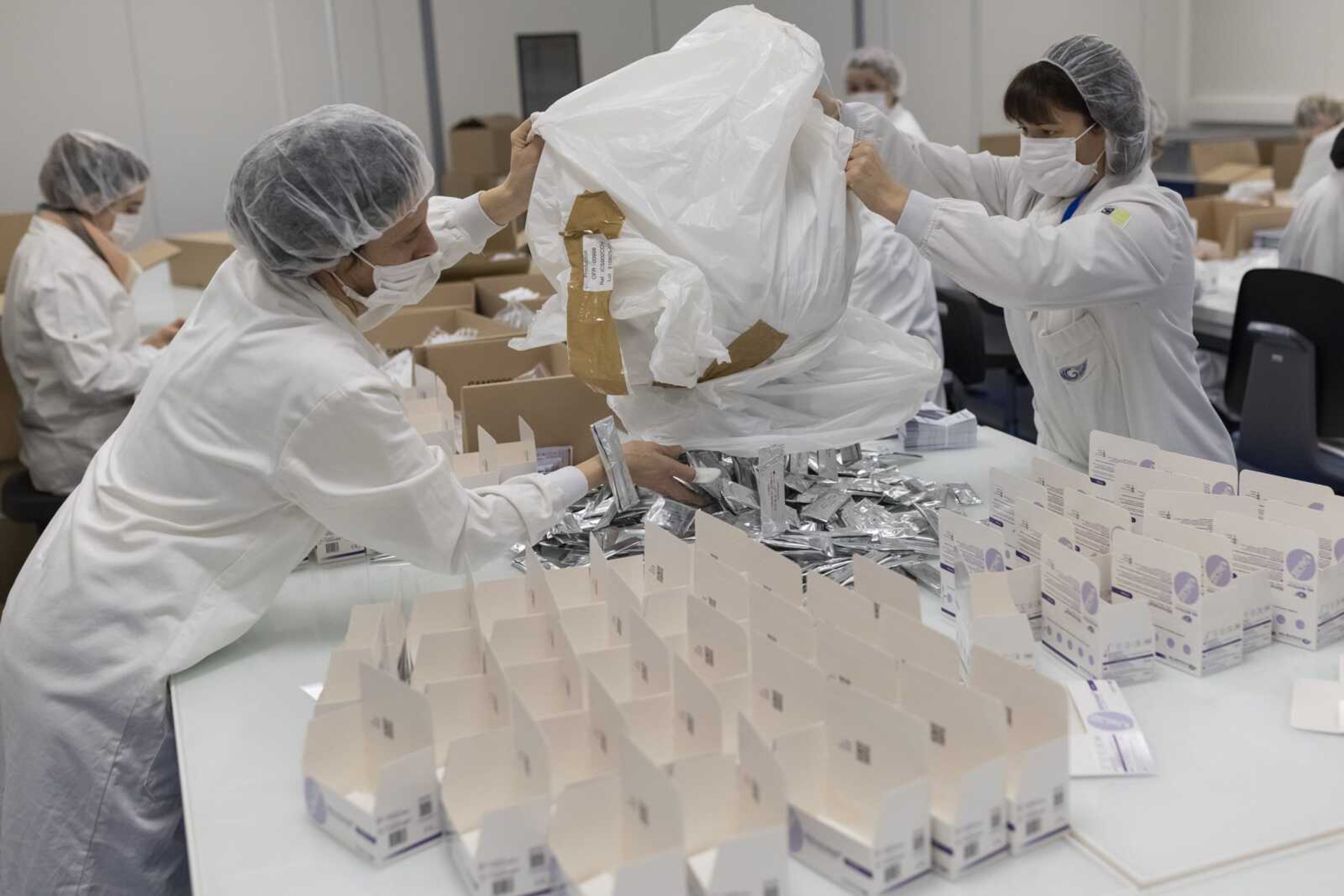 Employees work on an assembly line at NG Biotech, a start-up that makes an array of medical tests, including kits for use at home and by medical professionals to detect COVID-19 infections , in Guipry, western France on Friday.