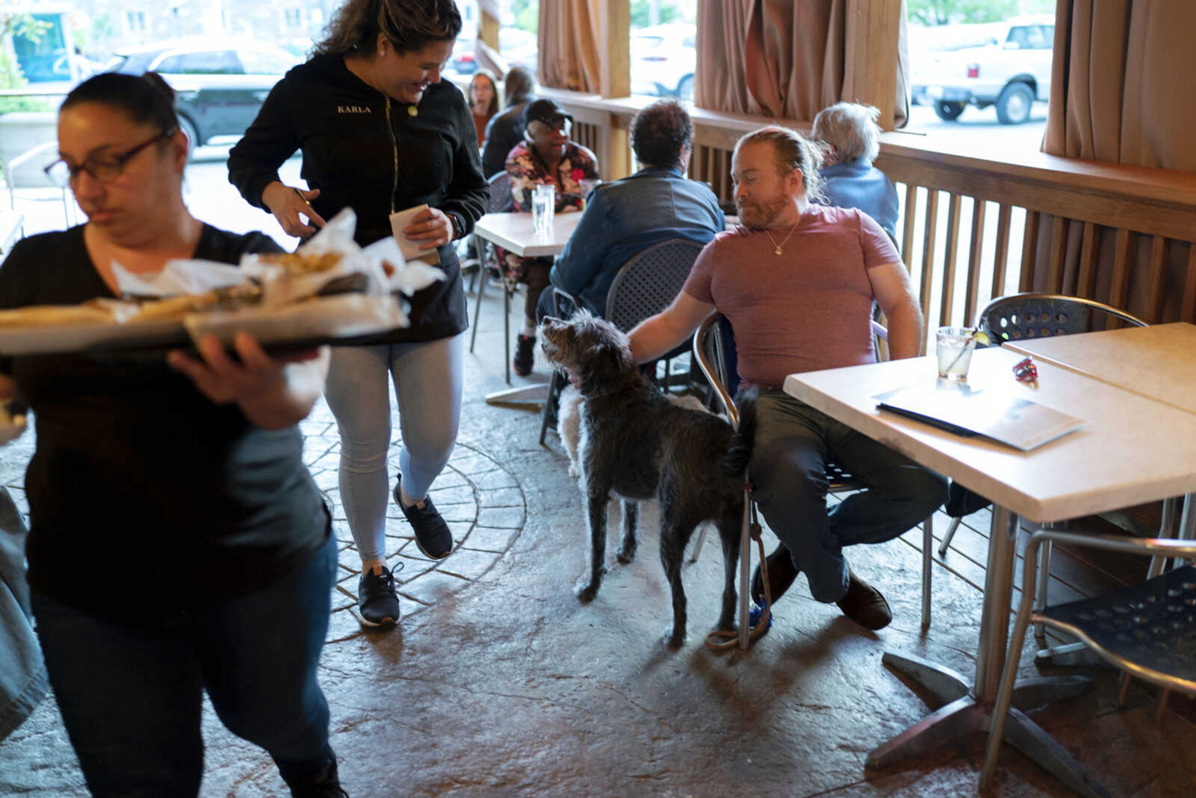 Monty Hobbs and his dog Mattox get ready to order on the patio at the Olive Lounge restaurant May 4 in Takoma Park, Maryland. Hobbs said Mattox is well-behaved, so it's nice to know they can drop in at a neighborhood bar if they're out taking a walk.