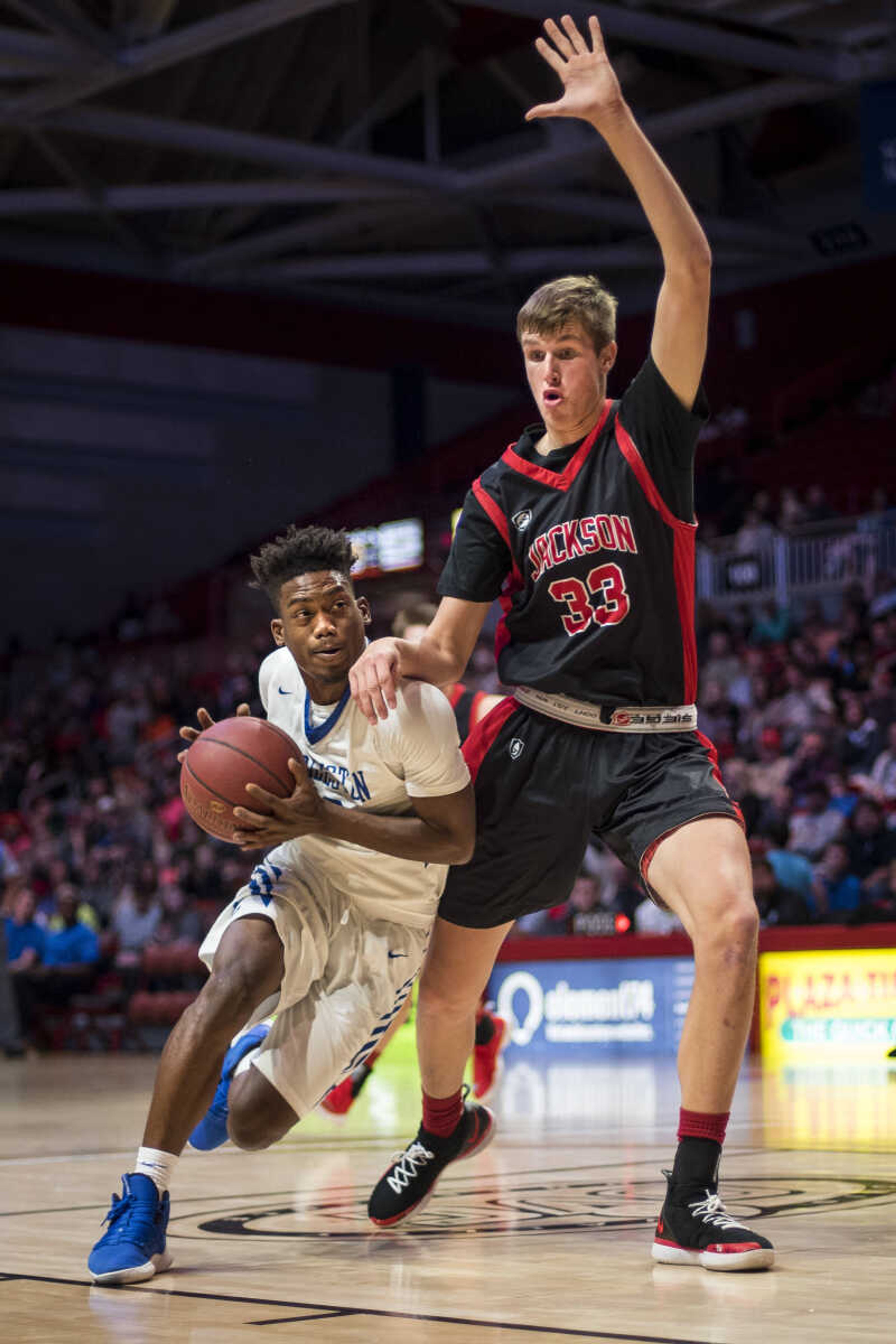 Charleston junior Isaiah Gillespie (40) drives toward the basket as Jackson's Seth Beussink (33) tries to block his path during a semifinal matchup at the Southeast Missourian Christmas Tournament Friday, Dec. 28, 2018.