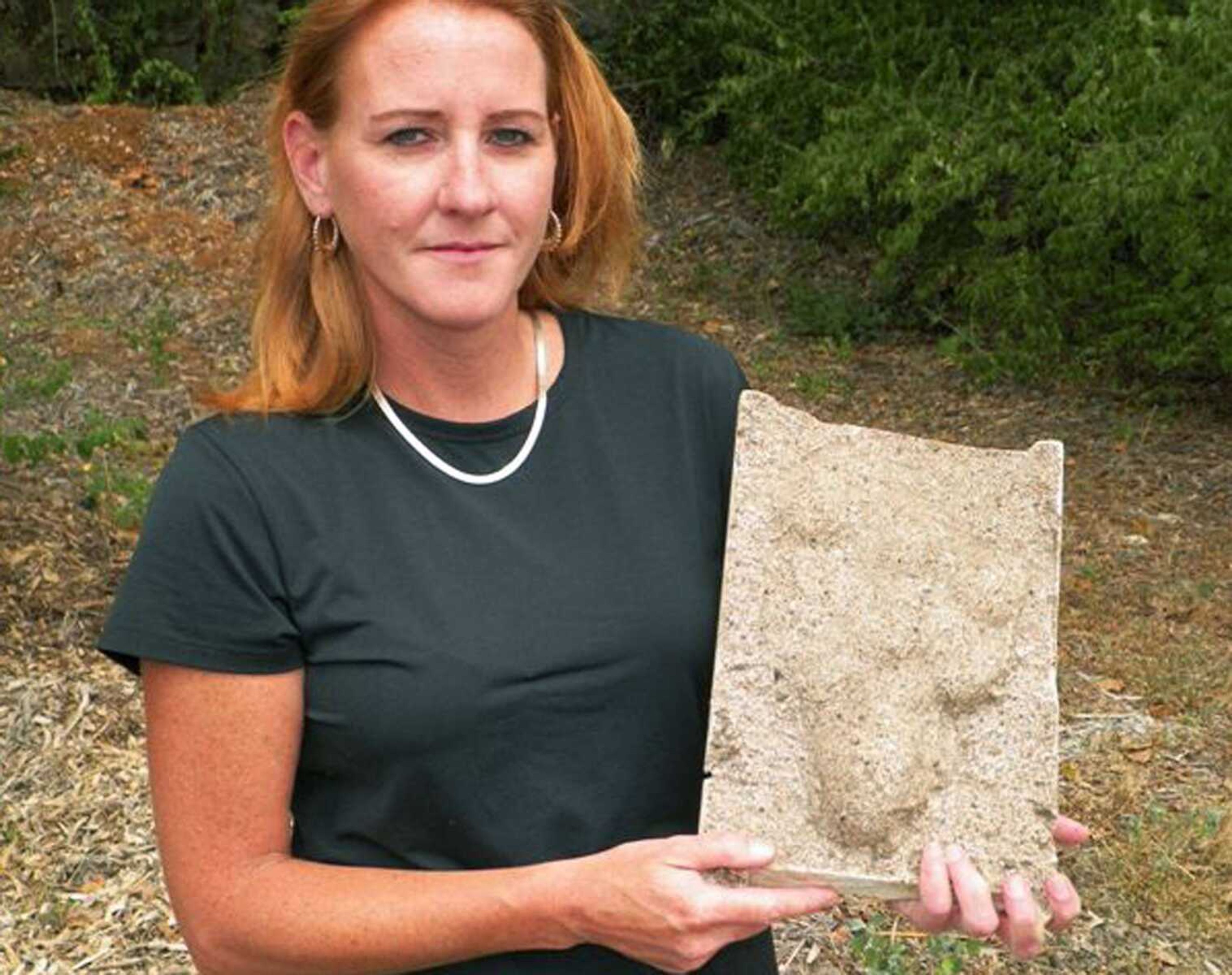 This July 11, 2012, photo shows Christiana Windmiller holding a plaster footprint made by her father purportedly left by a Sasquatch-like creature in a garden in Louisiana, Mo. For a couple of weeks 40 years ago, the tiny town was the center of the earth as people came from around the nation to help search for the mysterious beast. Four decades later, people in this historic old town on the banks of the Mississippi River are still debating whether the creature dubbed "Momo the Missouri Monster" really existed. (AP Photo/Jim Salter)