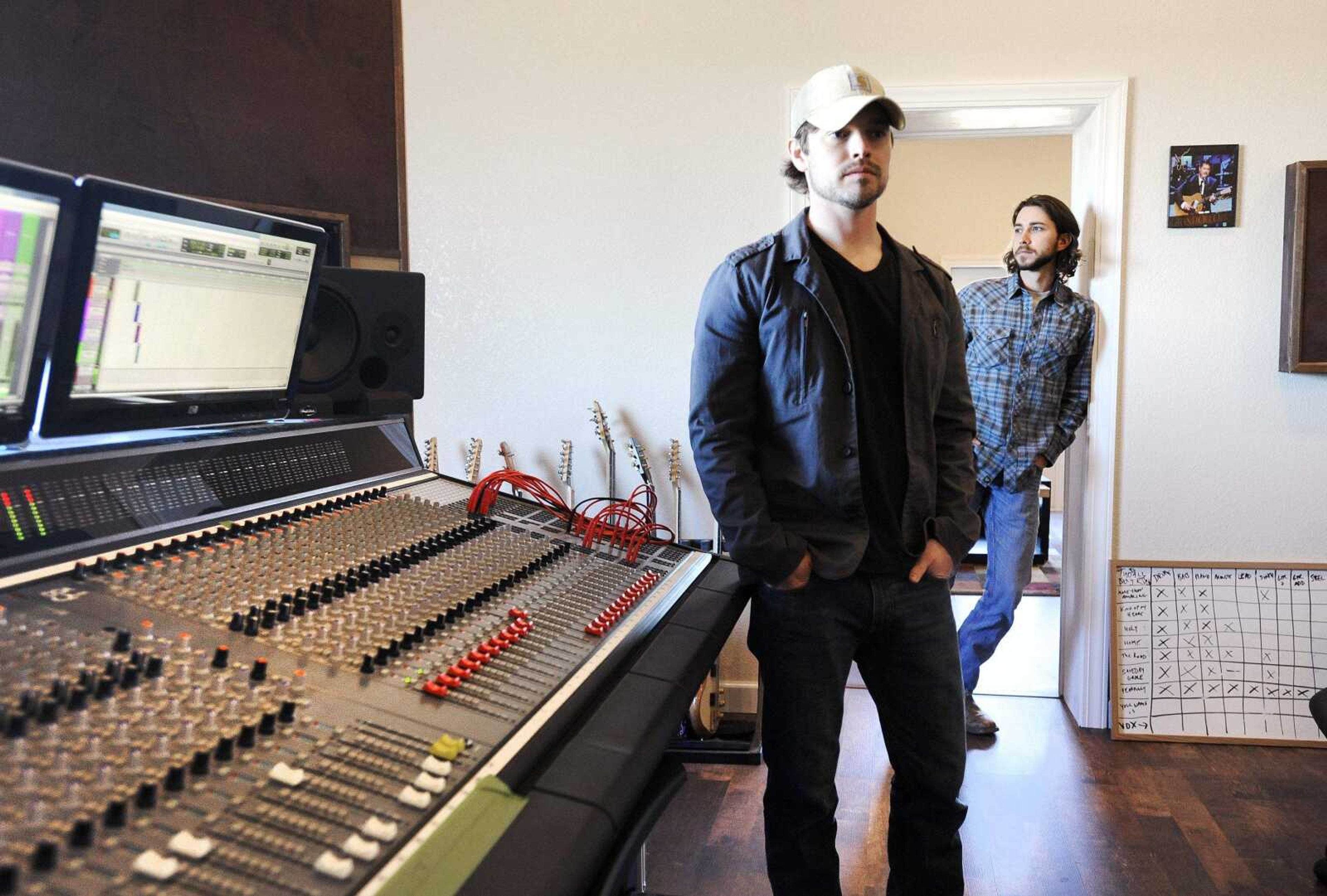 Adam Hellman, left, and Evan Webb, members of Evan Webb and the Rural Route Ramblers, pose for a photo Jan. 10 inside Blue Creek Production in Patton, Missouri. Hellman and Webb were putting the finishing touches on the band's new album, which includes the song "Dry up or Drown," which went viral during the recent flooding in the area.