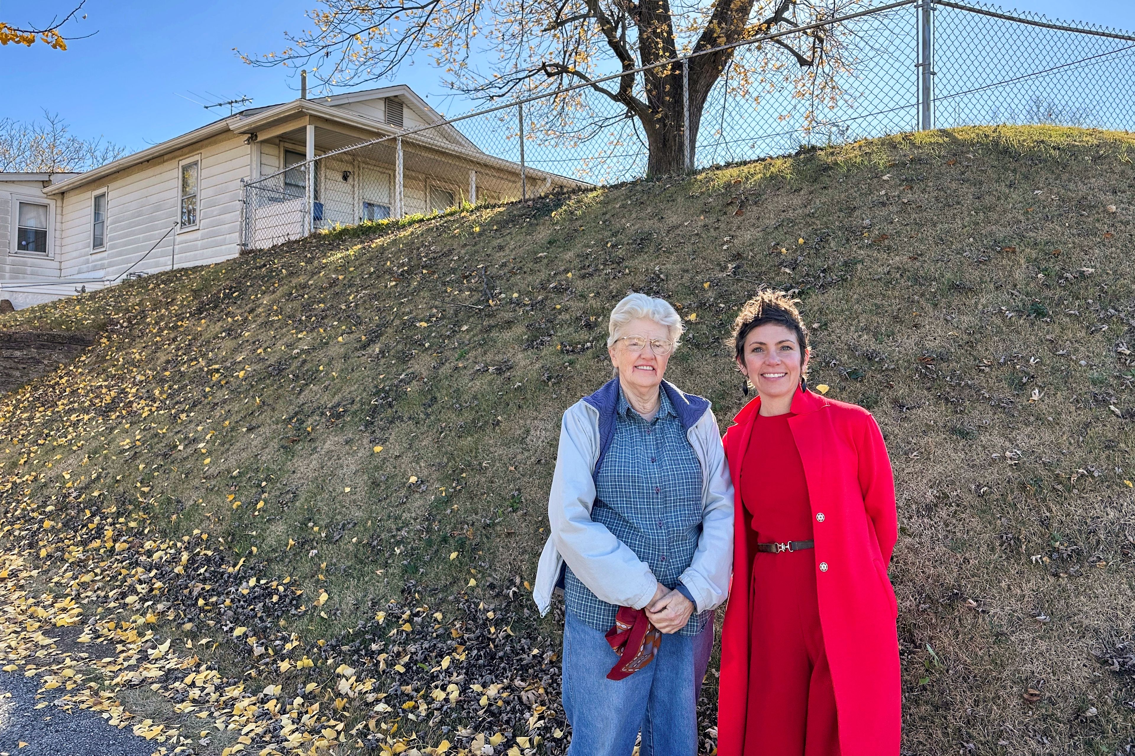 Joan Heckenberg and St. Louis Alderman Cara Spencer stand in front of Heckenberg's home, which sits atop the last remaining Native American mound in St. Louis, on Wednesday, Nov. 20, 2024. (AP Photo/Jim Salter)