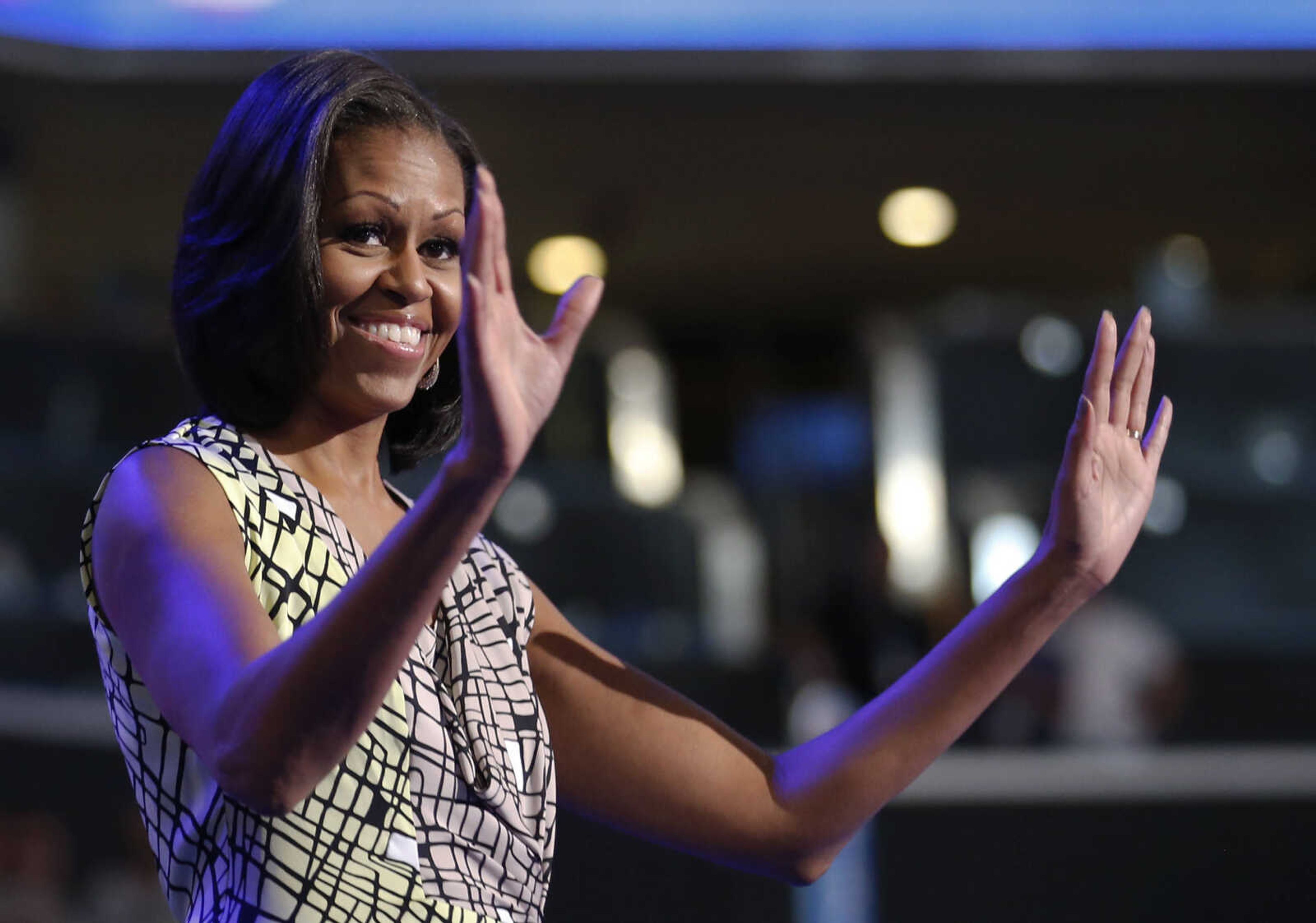 First Lady Michelle Obama waves as she appears at the podium for a camera test on the stage at the Democratic National Convention inside Time Warner Cable Arena in Charlotte, N.C., on Monday, Sept. 3, 2012. (AP Photo/Jae C. Hong)