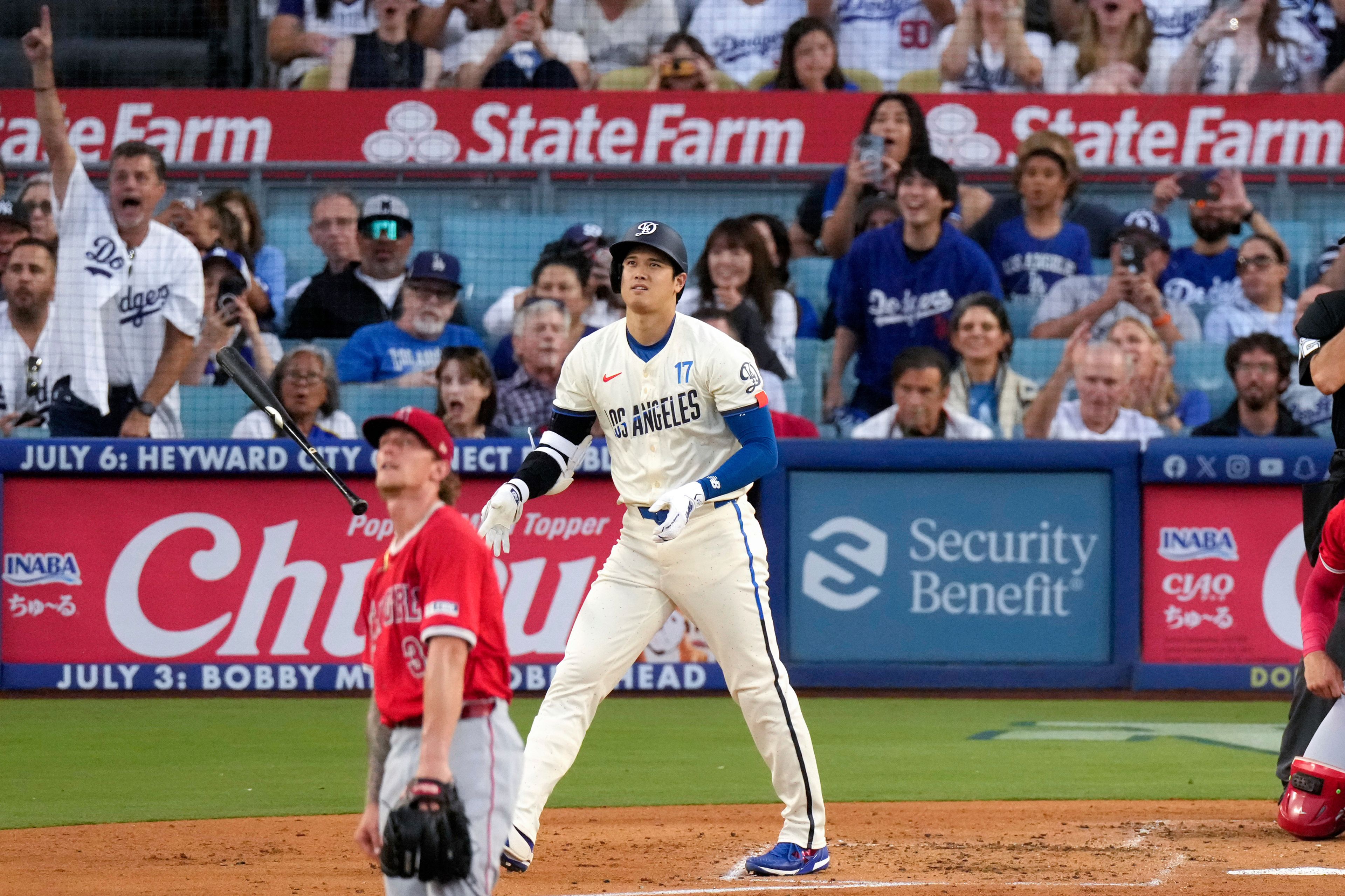 Los Angeles Dodgers' Shohei Ohtani, right, heads to first for a two-run home run as Los Angeles Angels starting pitcher Zach Plesac watches during the third inning of a baseball game Saturday, June 22, 2024, in Los Angeles. (AP Photo/Mark J. Terrill)