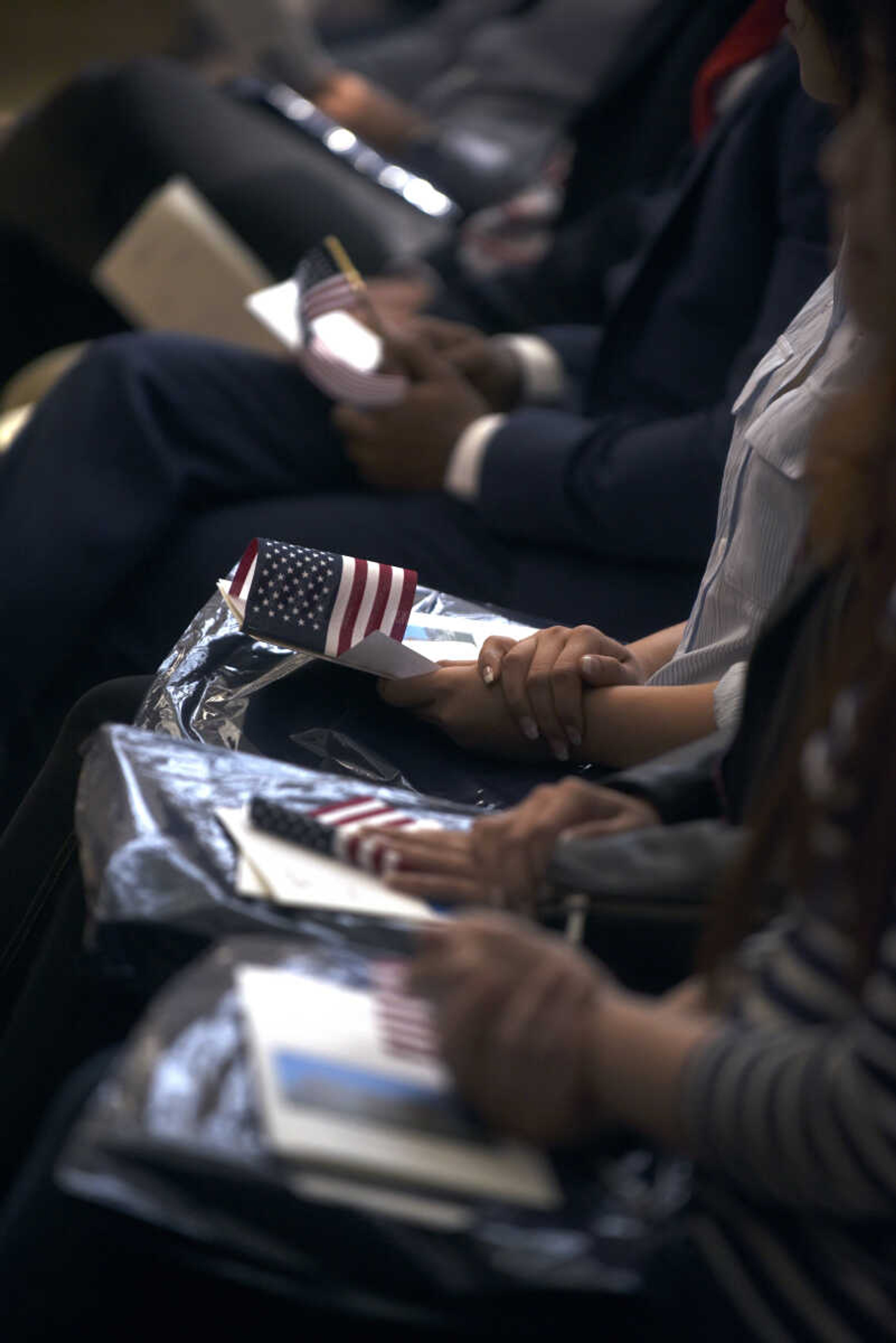 Candidates for American citizenship sit holding American flags during the United States District Court Eastern District of Missouri Southeastern Division's naturalization ceremony on Friday, April 6, 2018, at the Rush Hudson Limbaugh, Jr., United States Courthouse in Cape Girardeau.