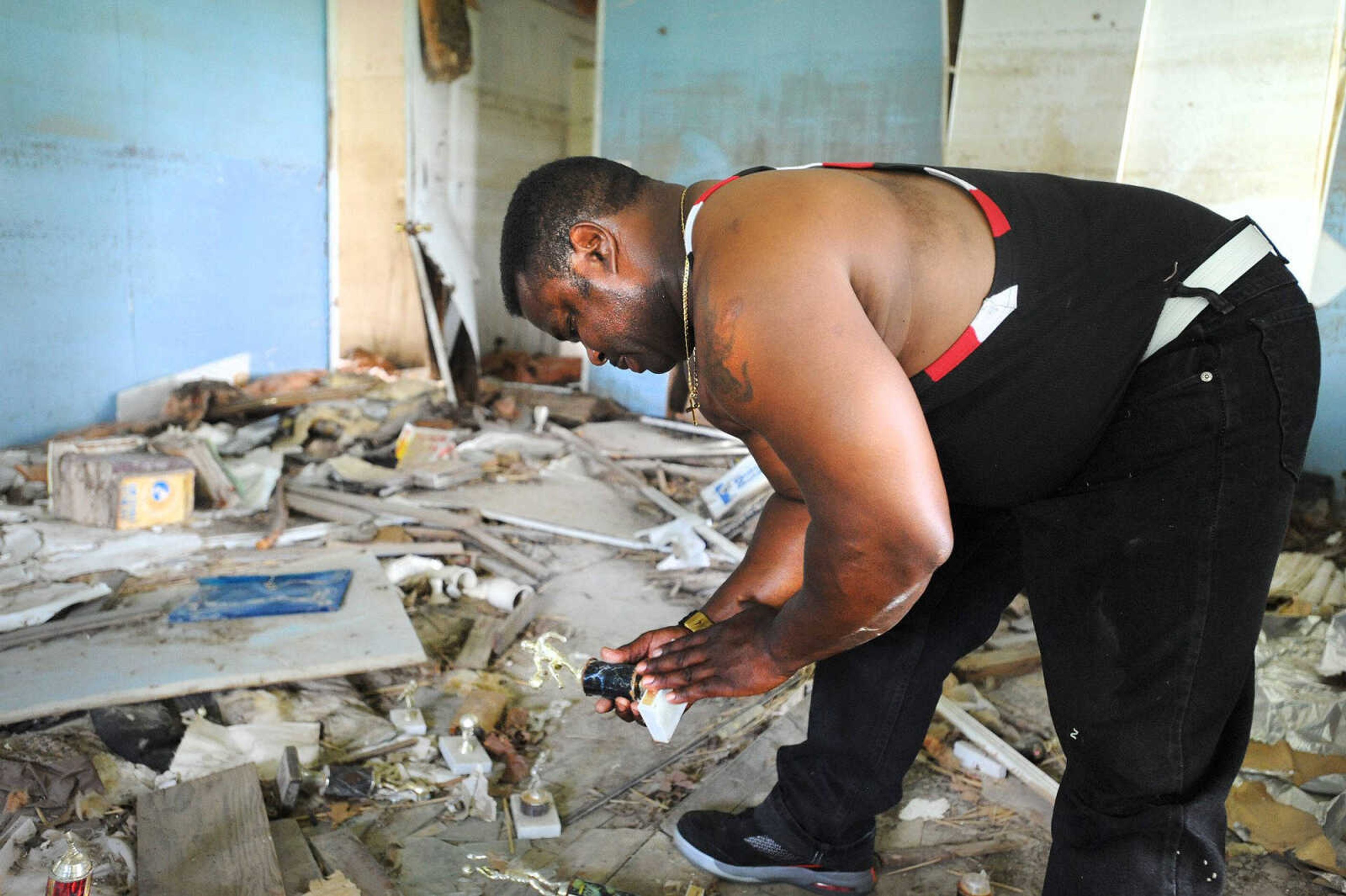 Reginald Robinson looks over one of several trophies laying inside his cousin's vacant Pinhook, Missouri, home Thursday. (Laura Simon)