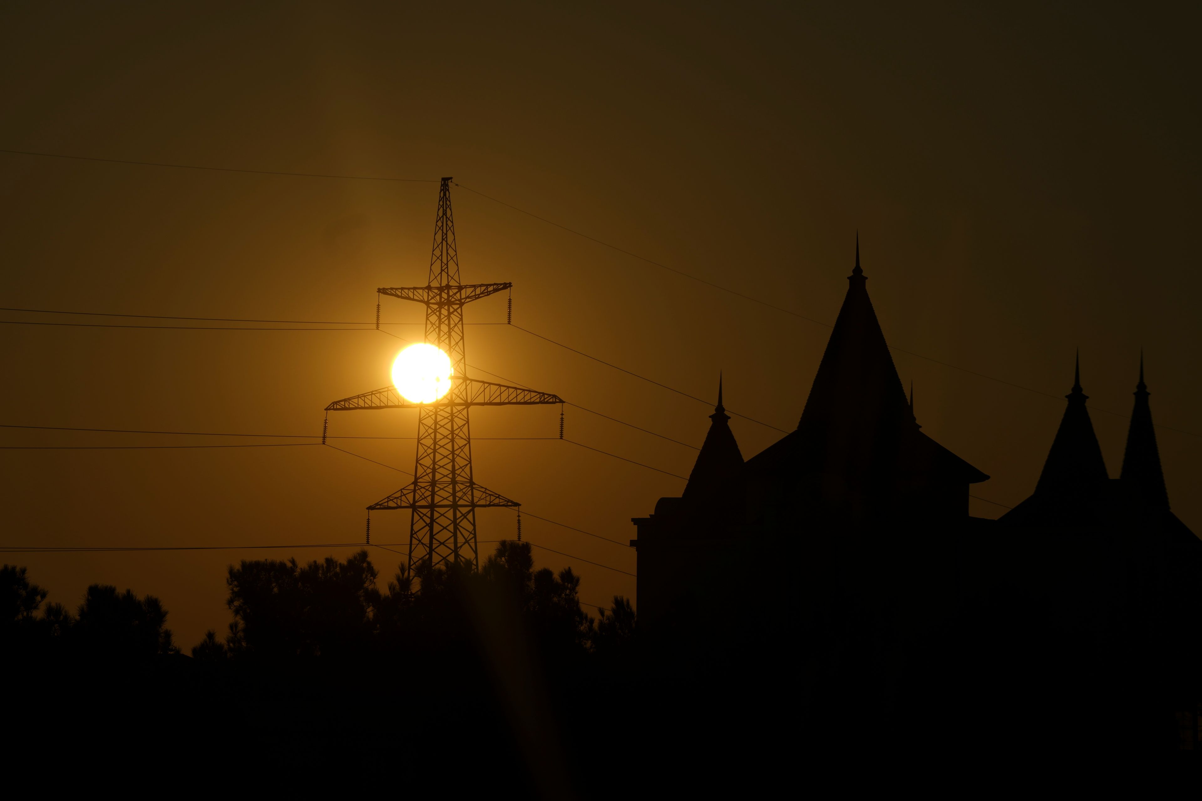 The sun rises visible behind a transmission tower during the COP29 U.N. Climate Summit, Friday, Nov. 22, 2024, in Baku, Azerbaijan. (AP Photo/Peter Dejong)