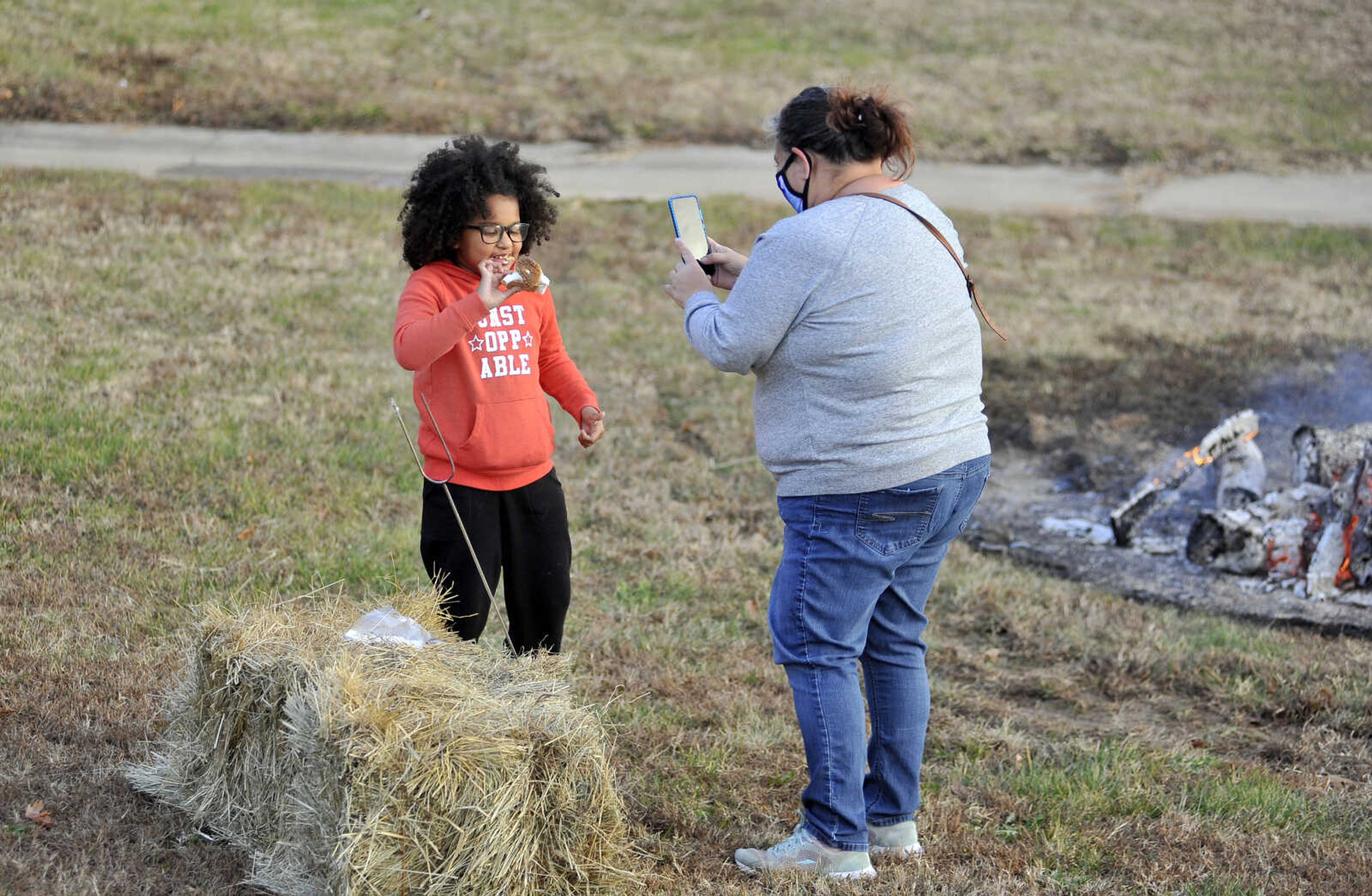 Arianna, 7, lets her mom, Kimberly Milner, take a photo of her while Arianna takes a bite of a s'more at the Fall Family Festival on Sunday, Nov. 22, 2020, at Shawnee Park Center in Cape Girardeau.