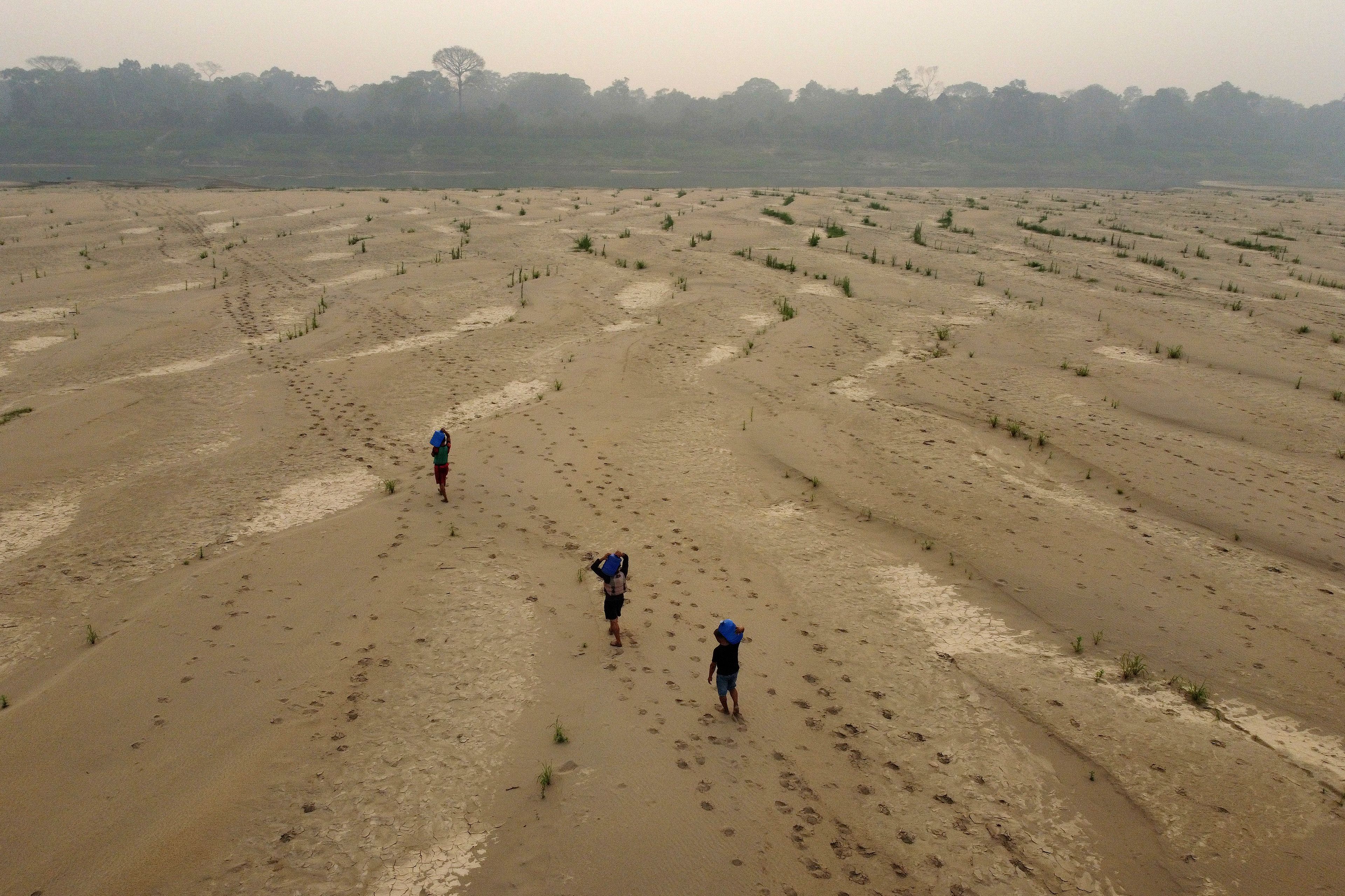 Residents transport drinking water from Humaita to the Paraizinho community, along the dry Madeira River, a tributary of the Amazon River, during the dry season, Amazonas state, Brazil, Sunday, Sept. 8, 2024. (AP Photo/Edmar Barros)