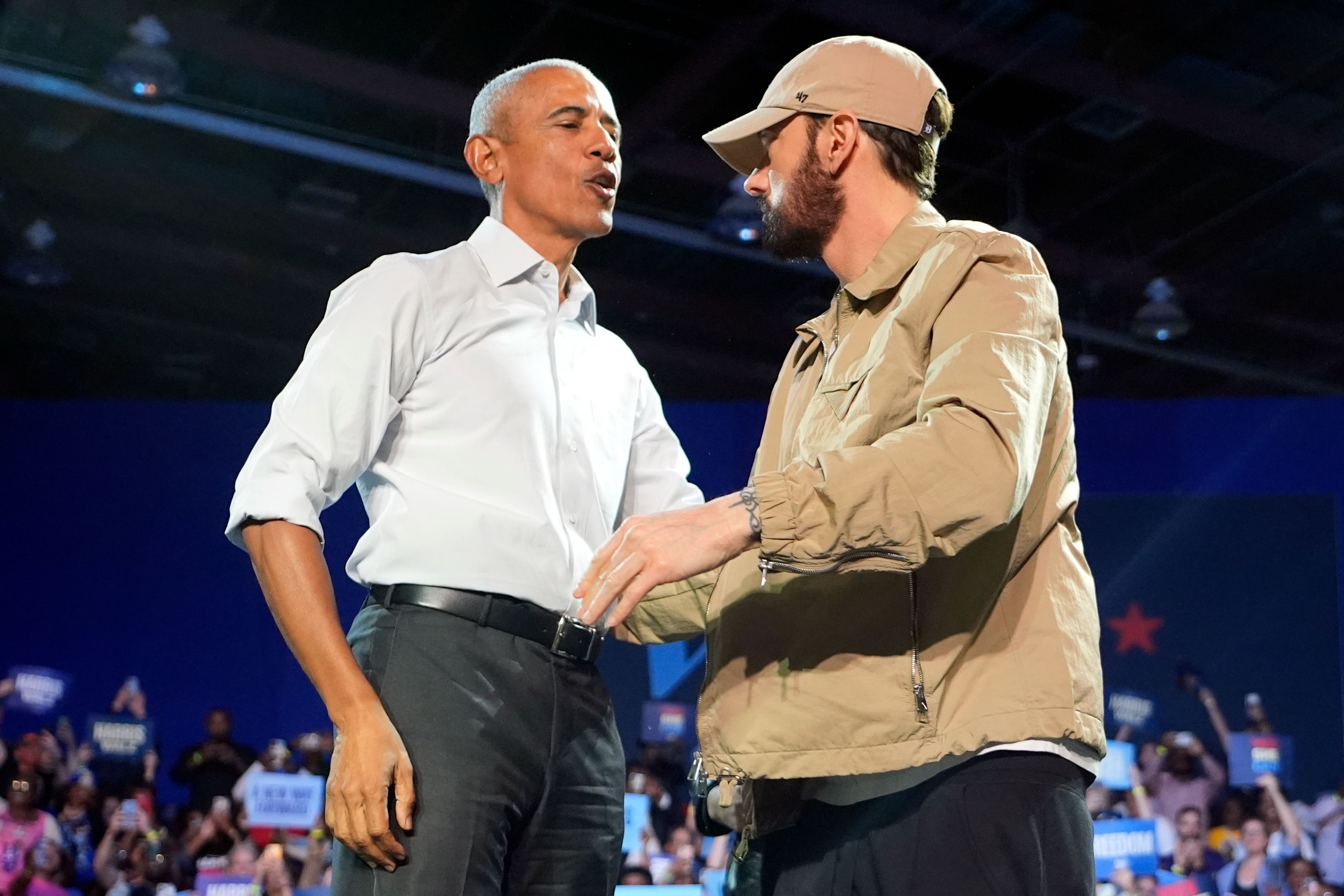 Rapper Eminem, right, greets former President Barack Obama, left, on stage at a campaign rally supporting Democratic presidential nominee Vice President Kamala Harris, Tuesday, Oct. 22, 2024, in Detroit. (AP Photo/Paul Sancya)