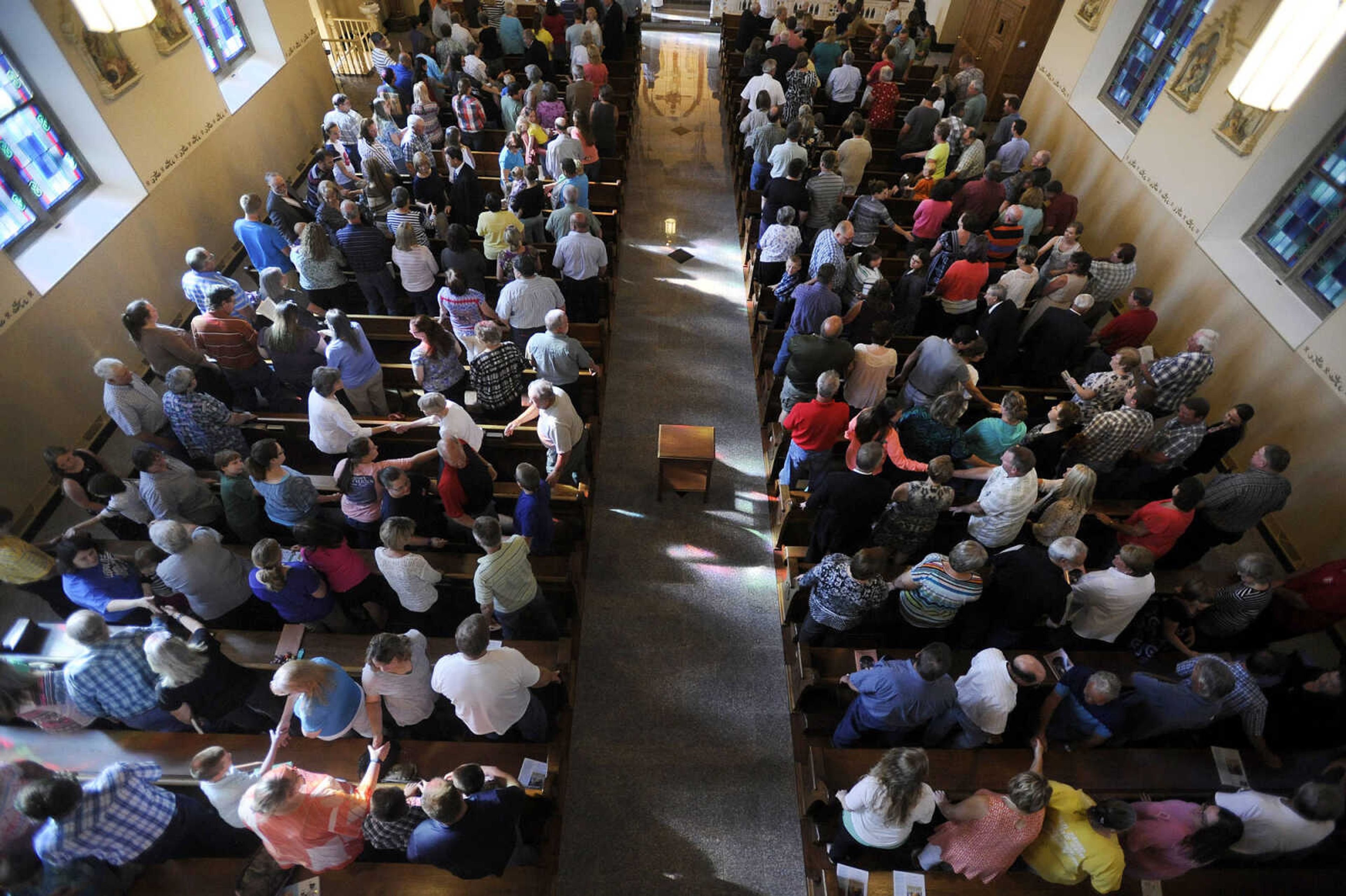 LAURA SIMON ~ lsimon@semissourian.com

Parishioners turn to each other in a sign of peace during the first mass inside the newly remodeled St. John's Catholic Church in Leopold, Missouri on Sunday, May 29, 2016.