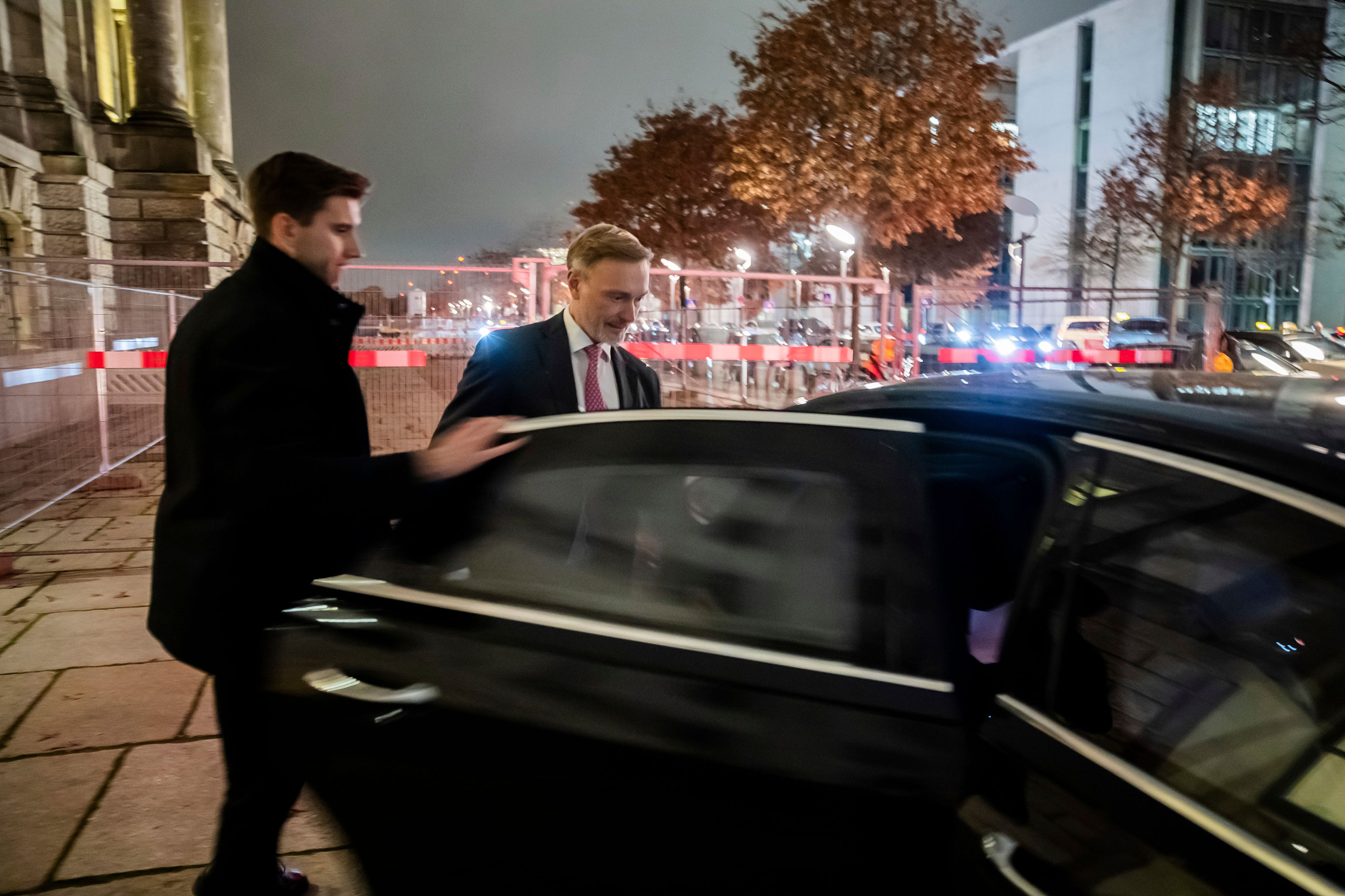 Federal Minister of Finance Christian Lindner, right, gets into his limousine in front of the Reichstag building after his dismissal by the Federal Chancellor Olaf Scholz and a parliamentary group meeting in Berlin, Wednesday, Nov. 6, 2024. (Christoph Soeder/dpa via AP)