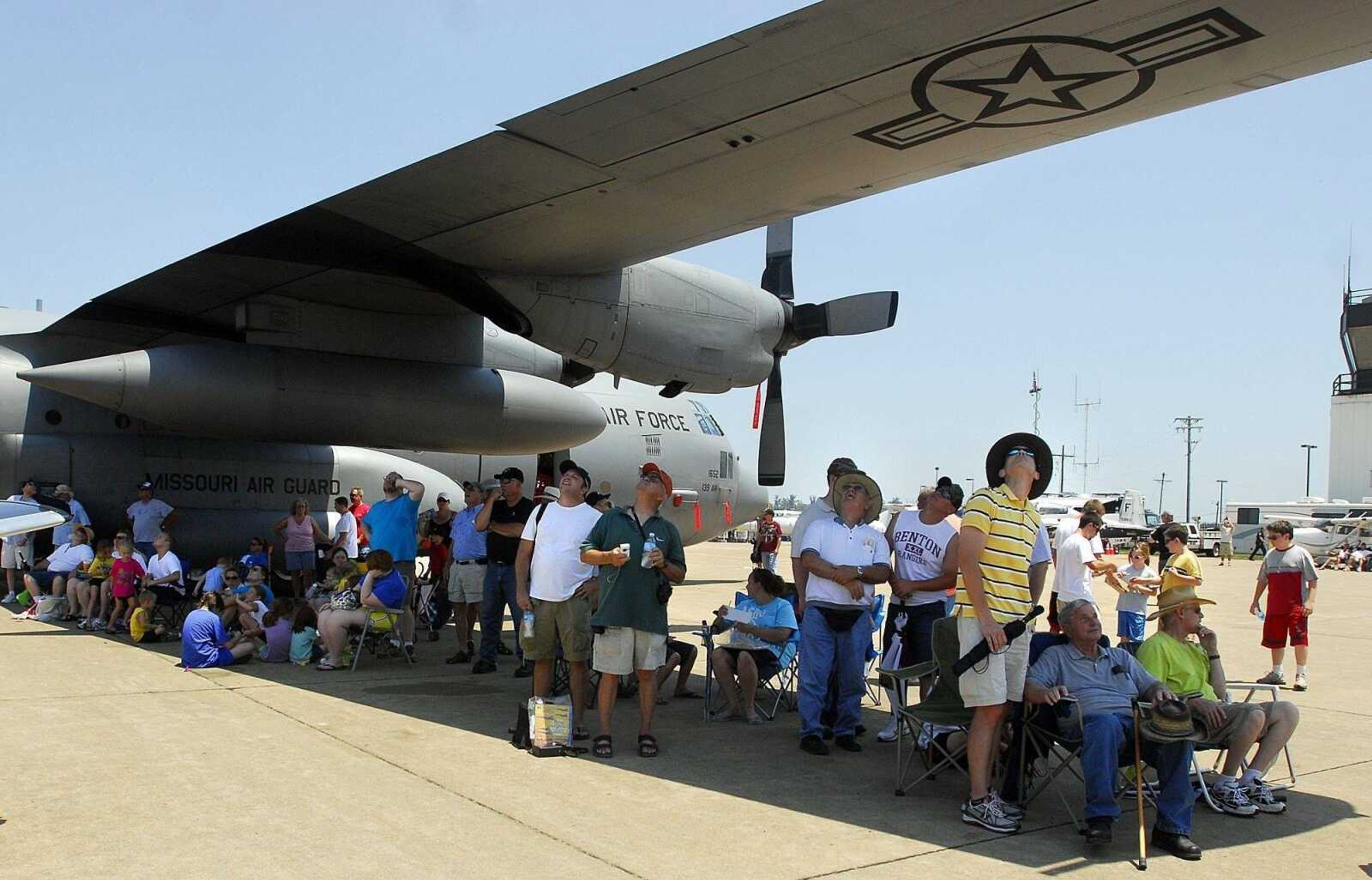 Visitors to the Cape Girardeau Regional Air Festival seek refuge from the sun under the wing of an aircraft Sunday, June 20, 2010. (Laura Simon)