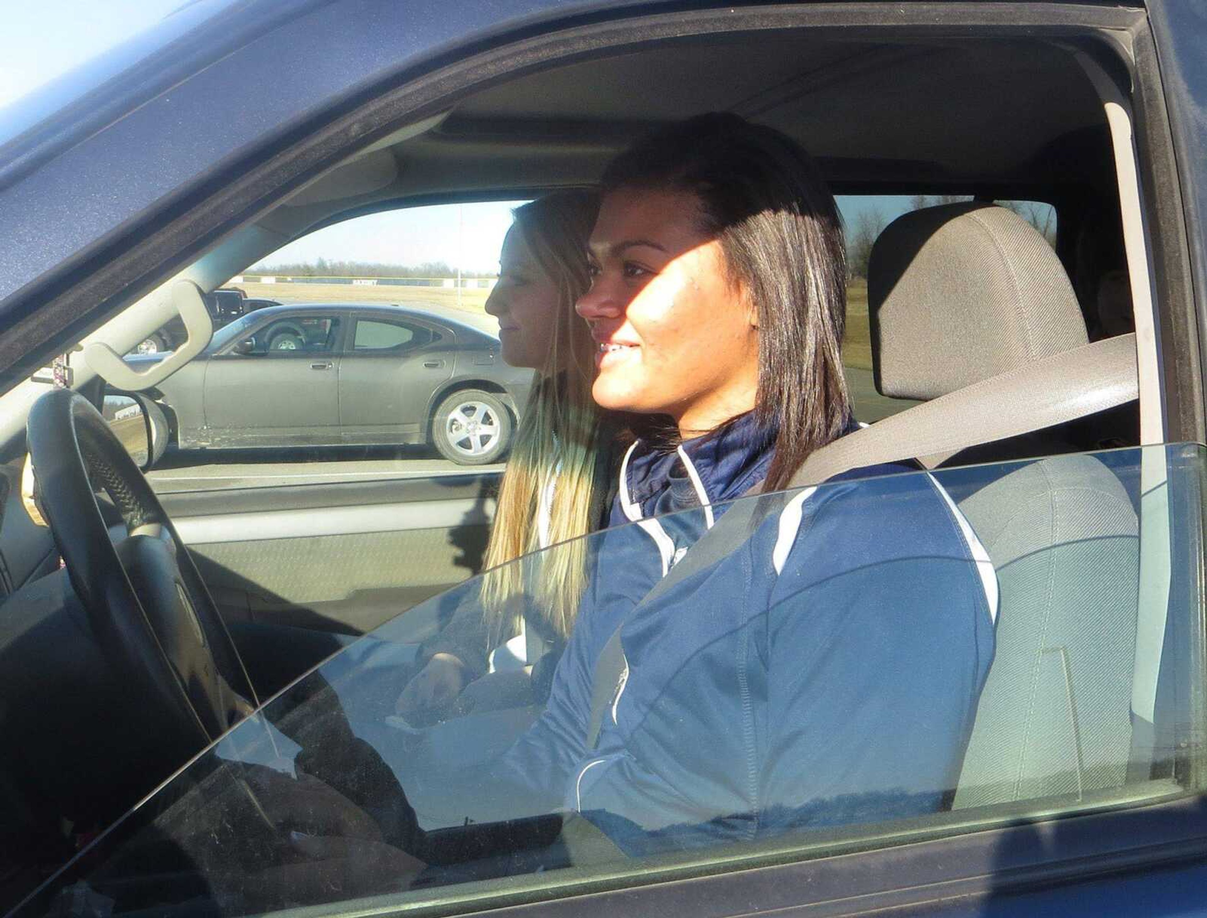 Saxony Lutheran High School students Ashlynn Collier, front, and Madison Spanley get ready to leave school Wednesday. The school recently received an award for its seat-belt usage. (Ruth Campbell)