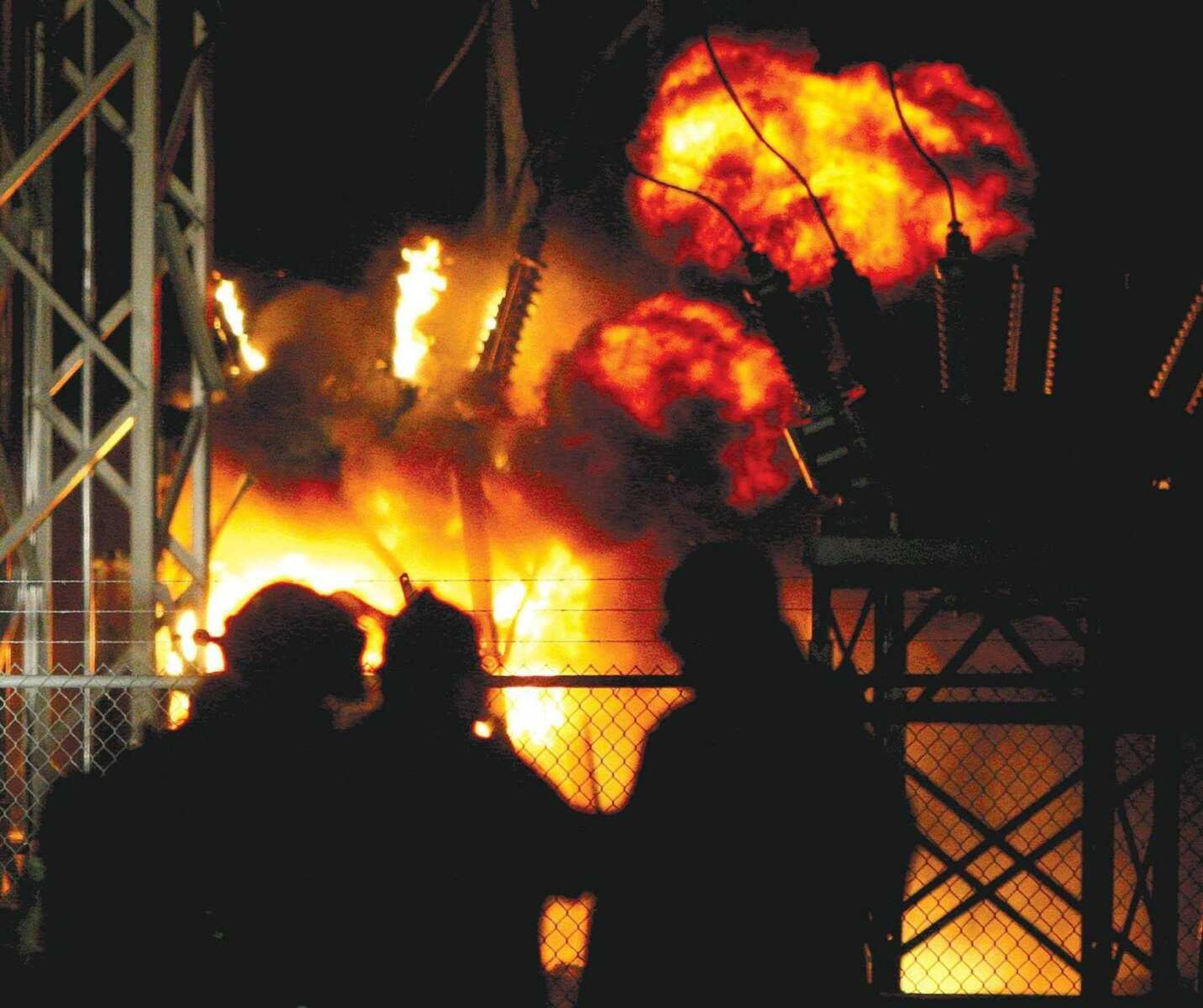 DAVID JENKINS ~ Standard Democrat<br>Firefighters with the Sikeston Department of Public Safety watch Wednesday night as a circuit breaker burns at the Coleman Substation in Sikeston, Mo.