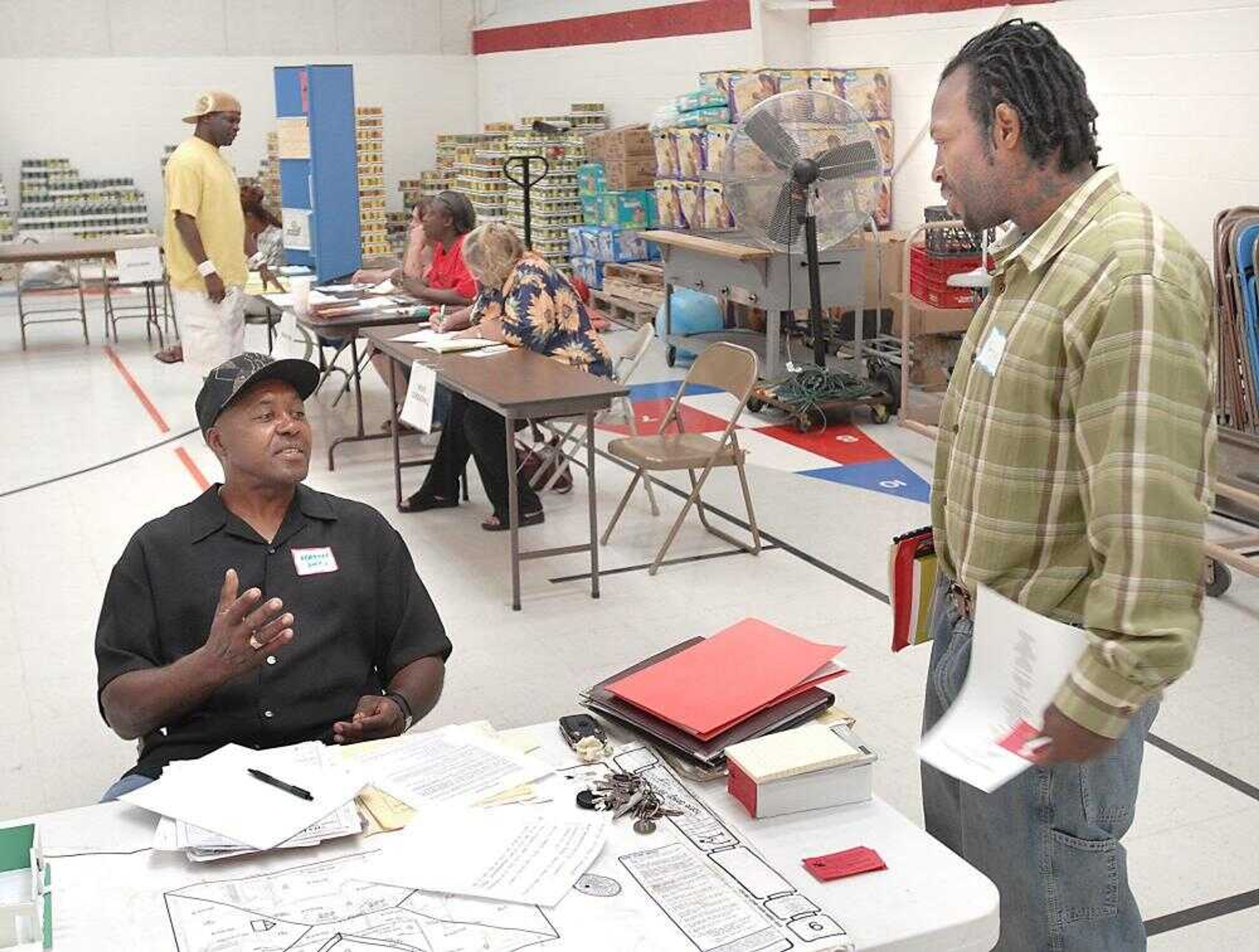 Joel Hatchett, left, a general contractor in Cape Girardeau, talked Wednesday with James Jones, who was considering employment opportunities at the Missouri Re-entry Process ex-offender job fair at the Salvation Army. (Fred Lynch)