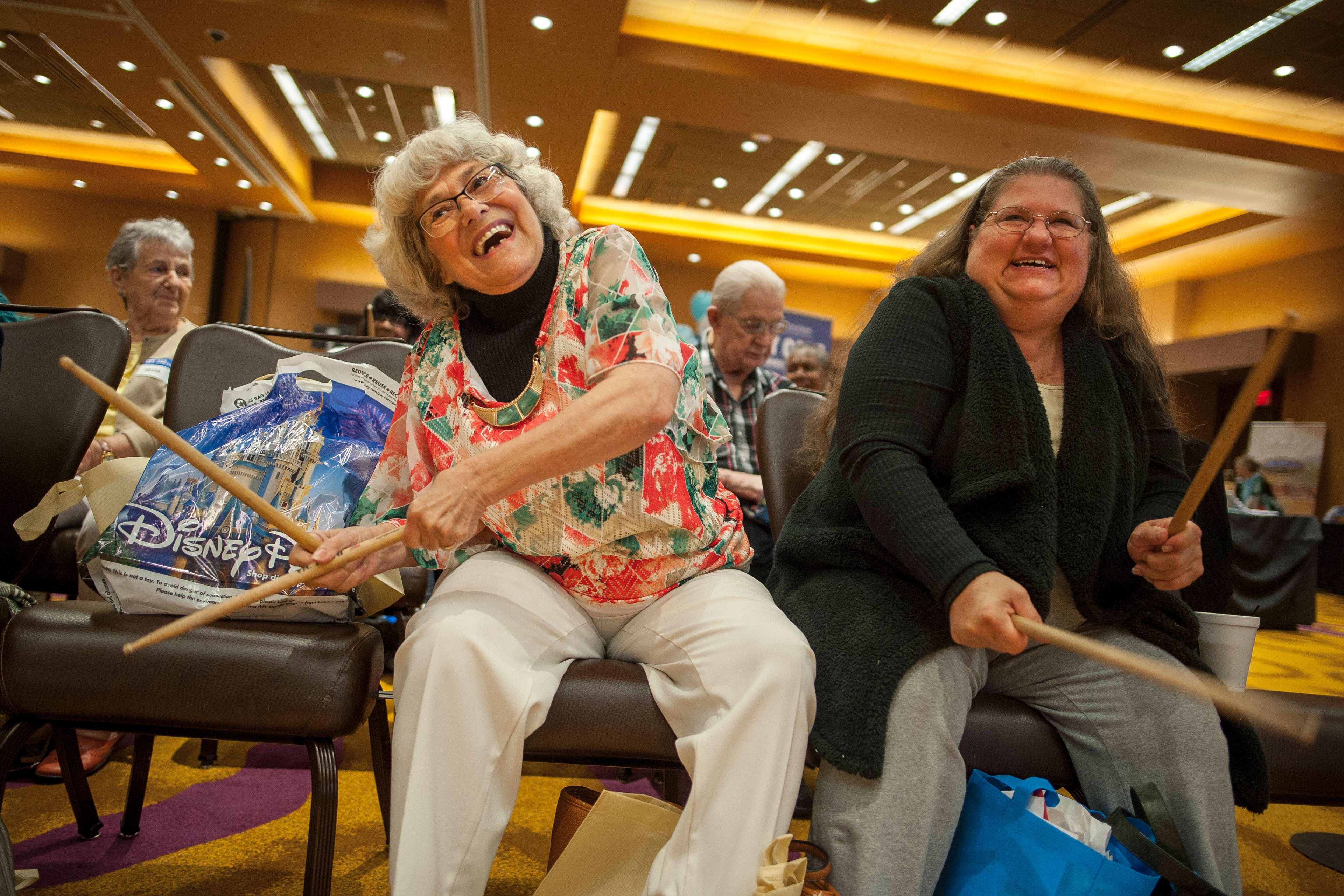 Valeria "Aunt Skeeters" Sanchez, left, and Mary Campbell play along during a cardio drumming exercise during the 2019 TBY Active Living Expo.