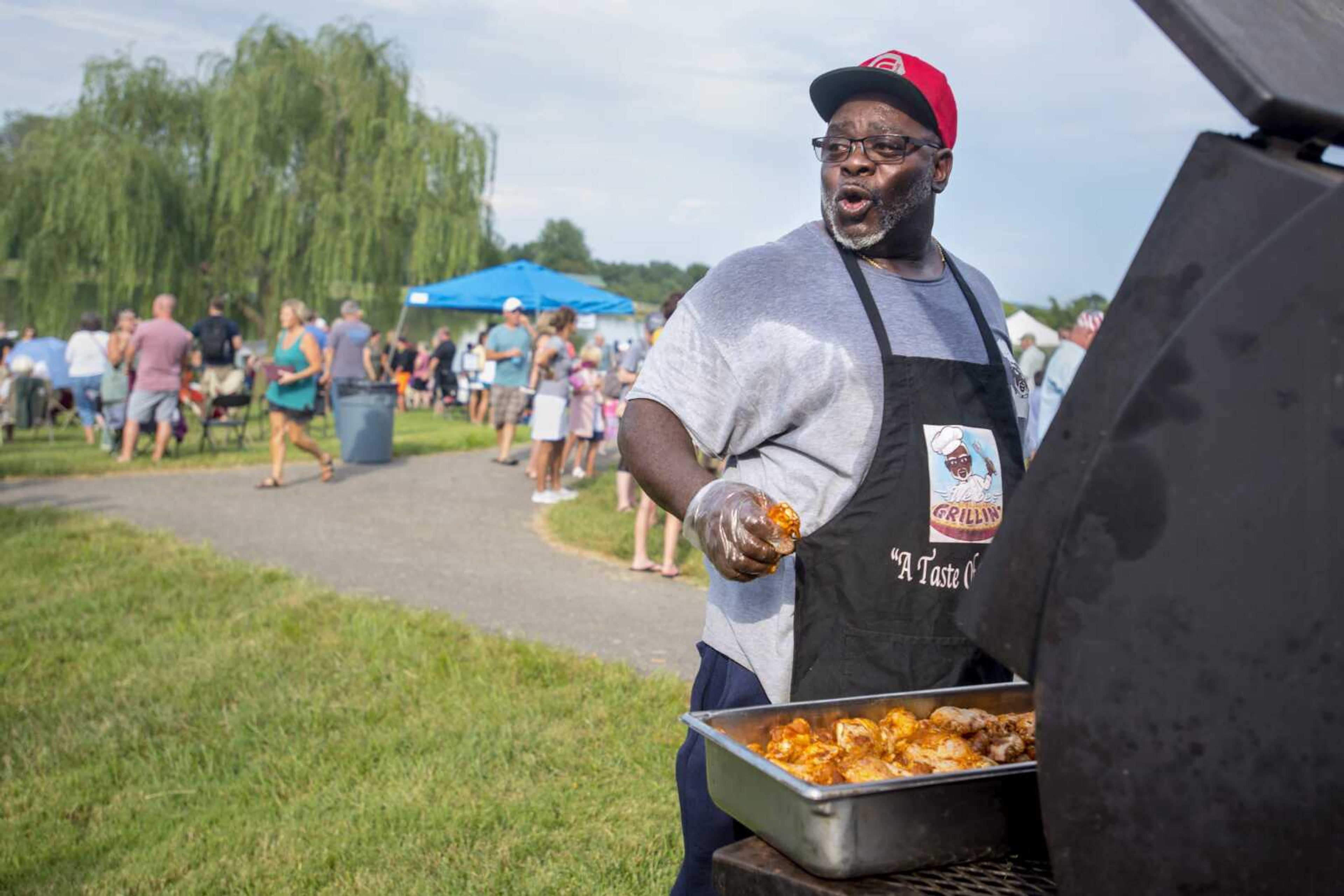 True-Que pitmaster and pastor Byron Bonner leans away from the heat of the grill while barbecuing at a "Sunday in the Park" event hosted by La Croix Church on Sunday, Aug. 18, 2019, at Cape County Park North in Cape Girardeau.