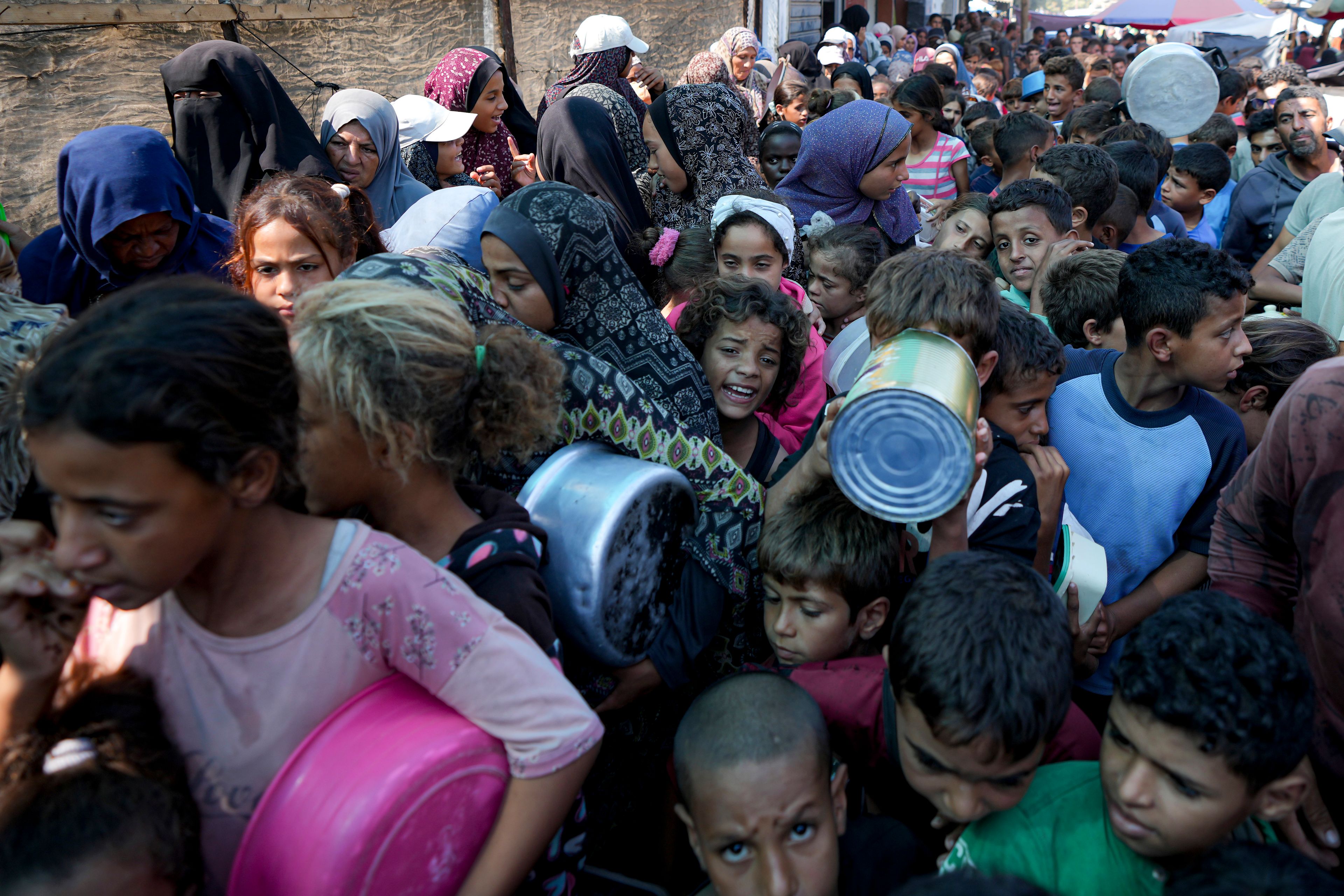 FILE - Palestinians line up for food distribution in Deir al-Balah, Gaza Strip, Thursday, Oct. 17, 2024. (AP Photo/Abdel Kareem Hana, File)