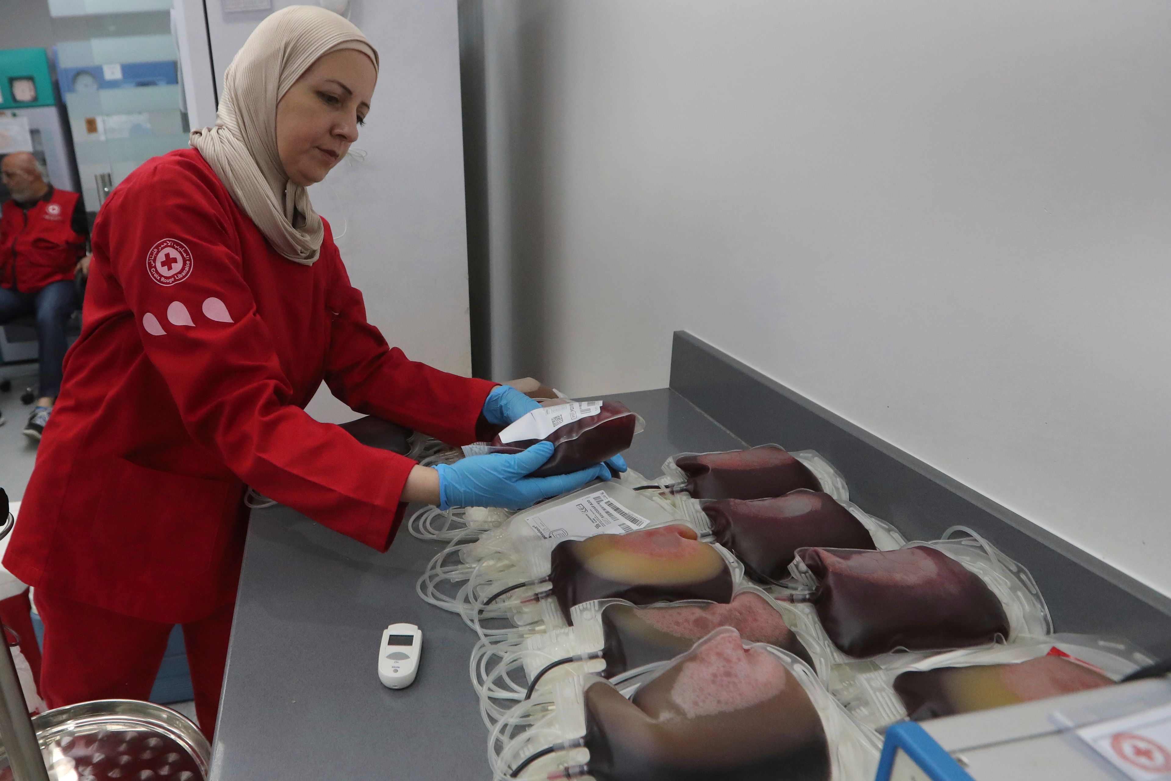 A Lebanese Red Cross volunteer collects blood donations for those who were injured by their exploded handheld pagers, Tuesday, Sept. 17, 2024, at a Red Cross center in the southern port city of Sidon, Lebanon. (AP Photo/Mohammed Zaatari)