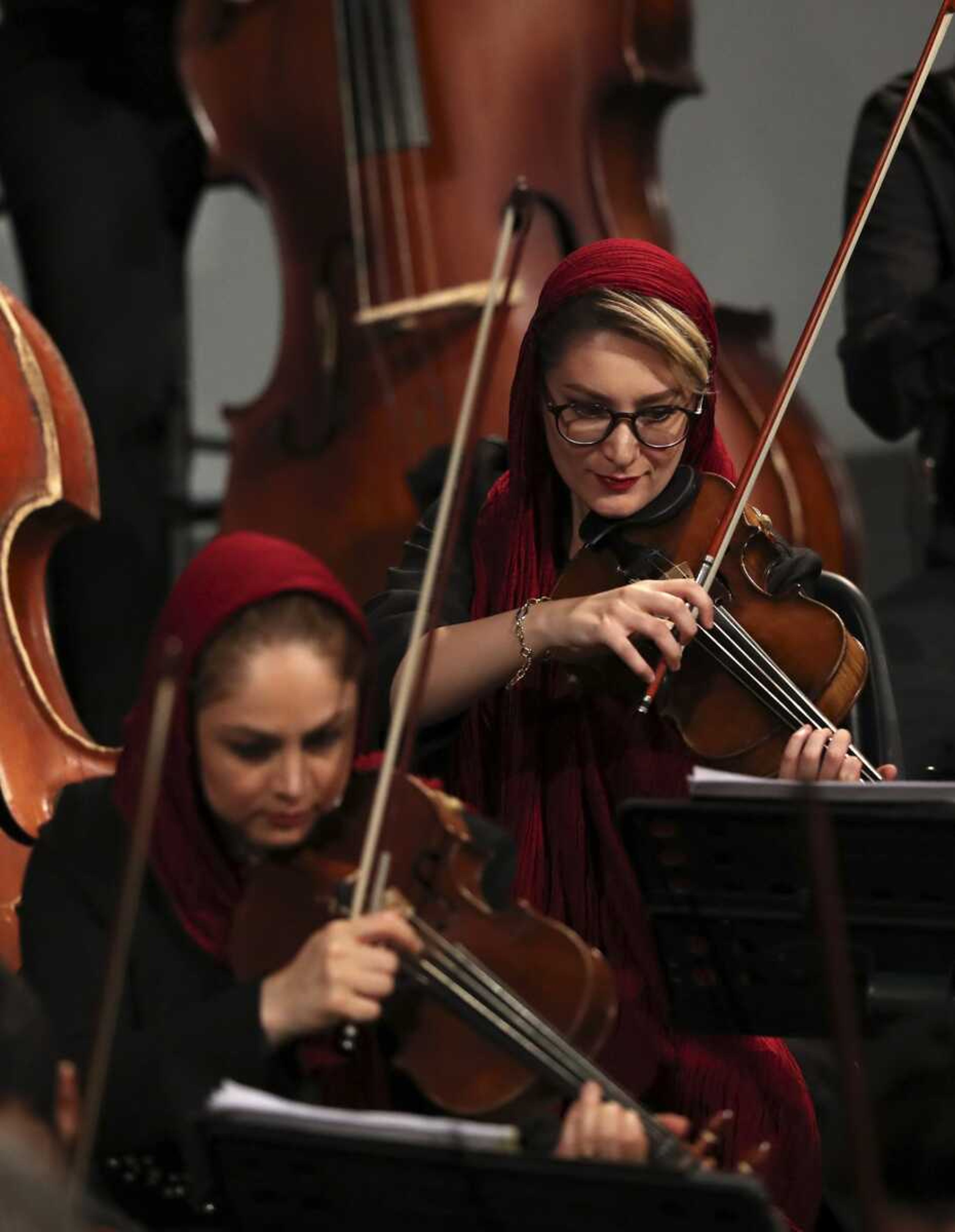 Iranian musicians play violin Wednesday, performing 19th-century Russian composers in Tehran Symphony Orchestra at Unity Hall, in Tehran, Iran.