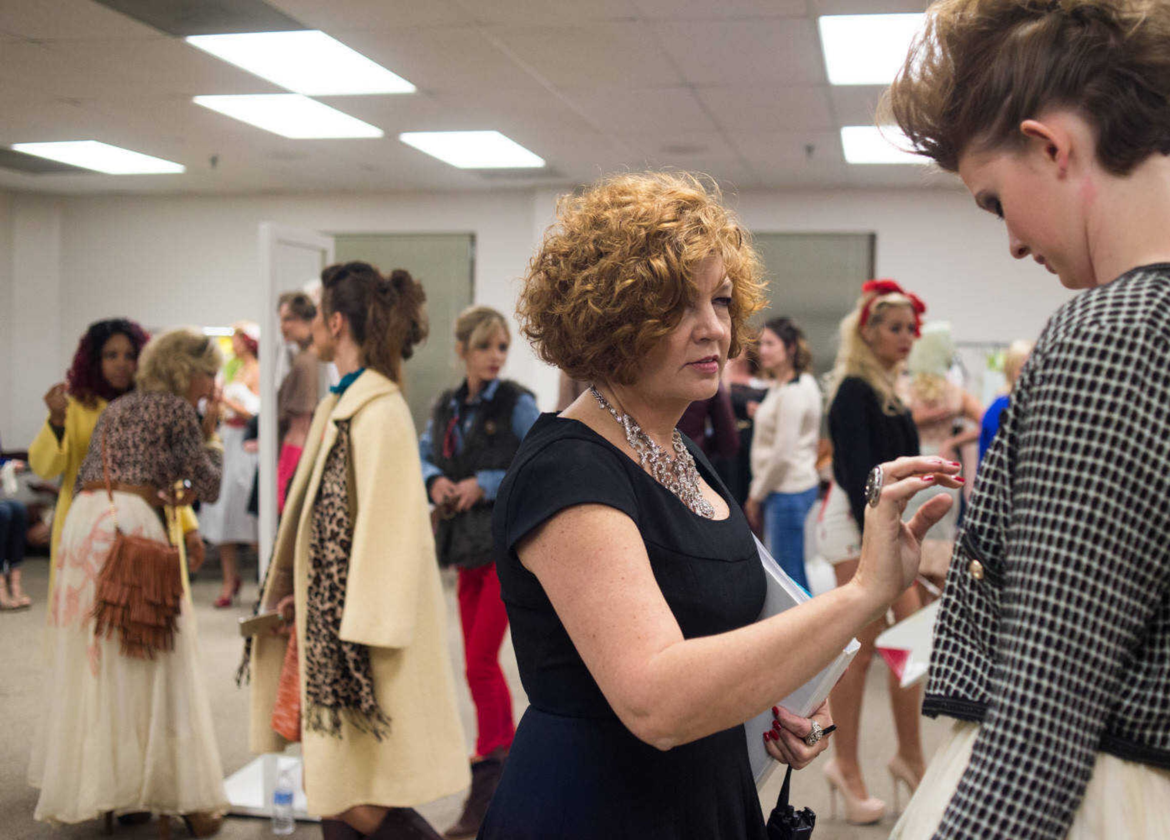 AARON EISENHAUER ~ photos@semissourian.com
Deb Maevers, founder and director of VintageNOW, makes a quick adjustment to Hayley Keith's wardrobe as the models prepare for the fifth annual VintageNOW fashion show, a fundraiser for Safe House for Women, at the Osage Centre on Friday, October 17, 2014.