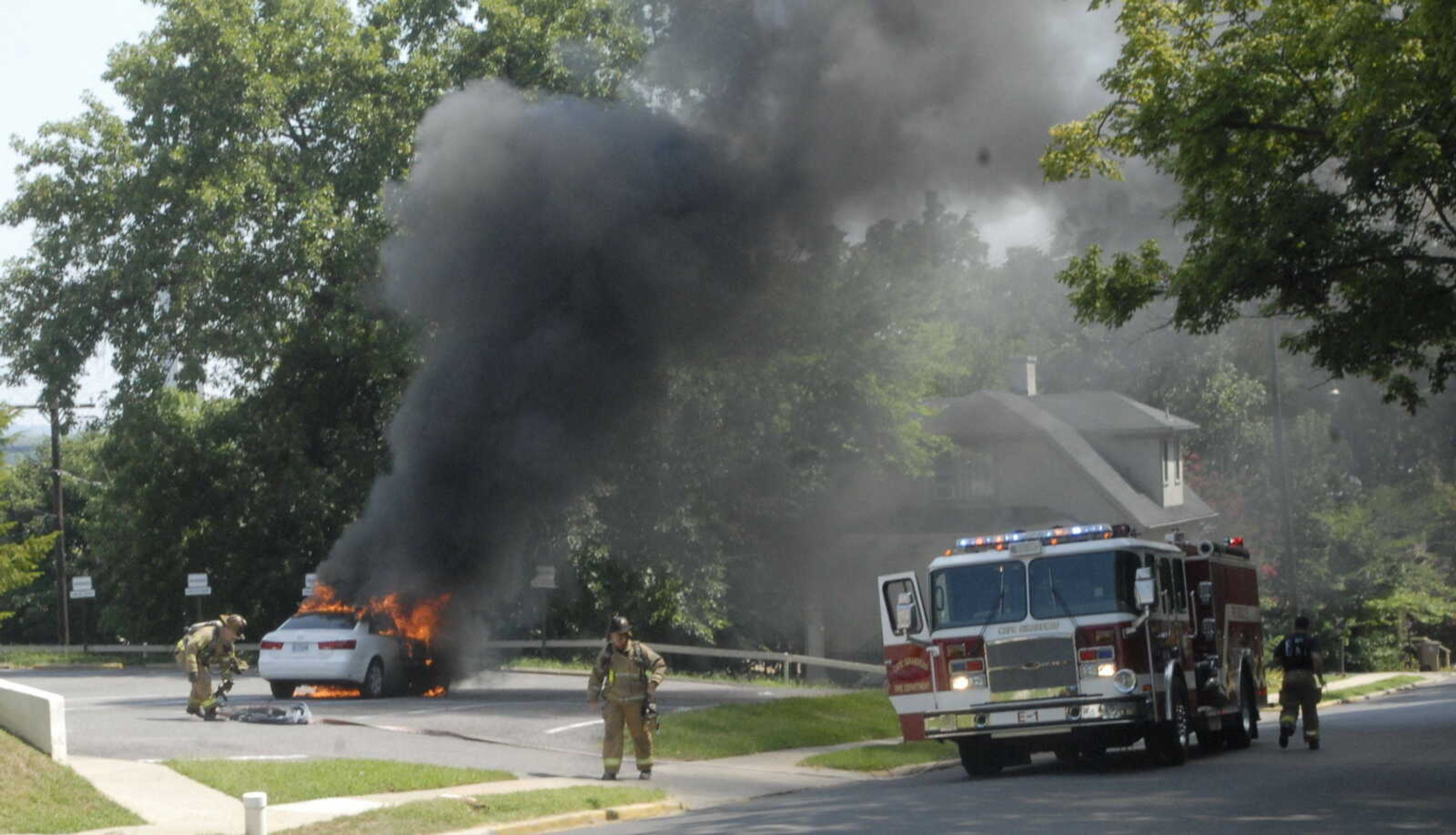 Cape Girardeau firefighters prepare to put out flames in a parked car near the Common Pleas Courthouse on Lorimier Street. (Melissa Miller)