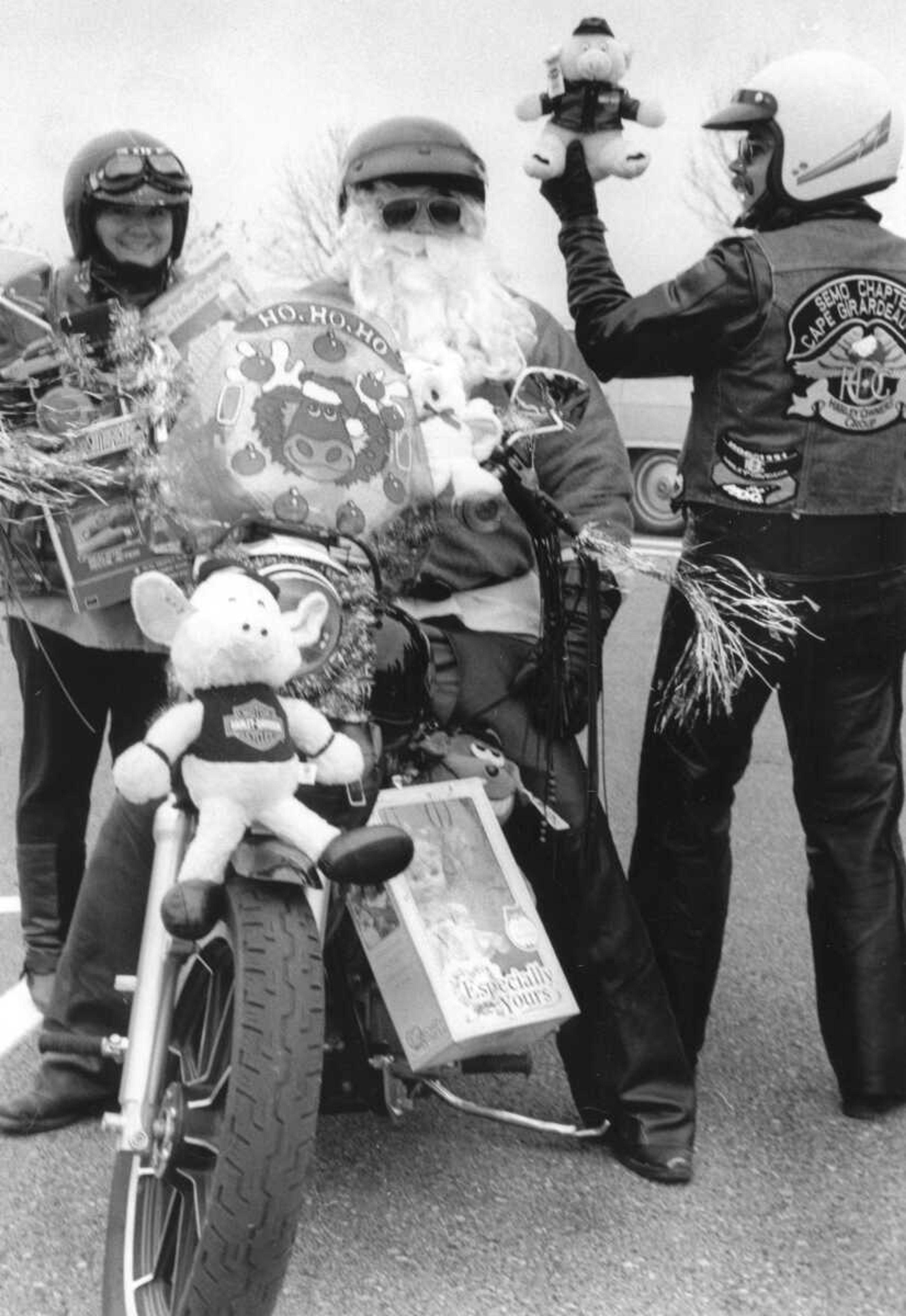 Published Dec. 7, 1992.
St. Nick, Brad Sample, and his helpers, Carol Hente, left, and Sonny Minor, braved the cold Sunday afternoon to participate in the Christmas spirit. Cape Girardeau's SEMO chapter Harley Owners Group donated toys to the Eagles Club. (Larry Thompson ~ Southeast Missourian archive)