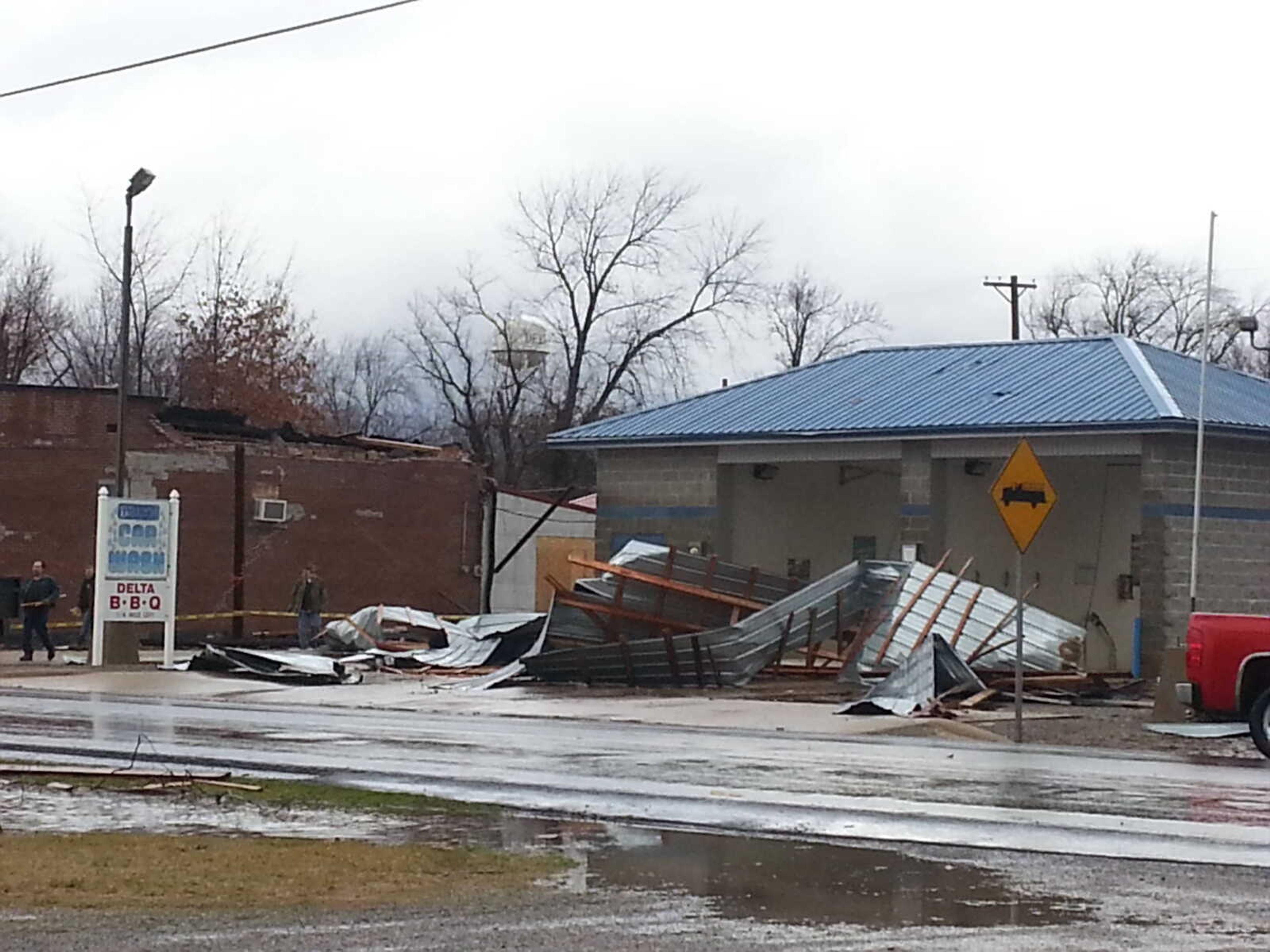 The metal roof of a convenience store is shown crumpled in the lot in front of a car wash on East State Street in Delta on Wednesday. (Laura Simon)