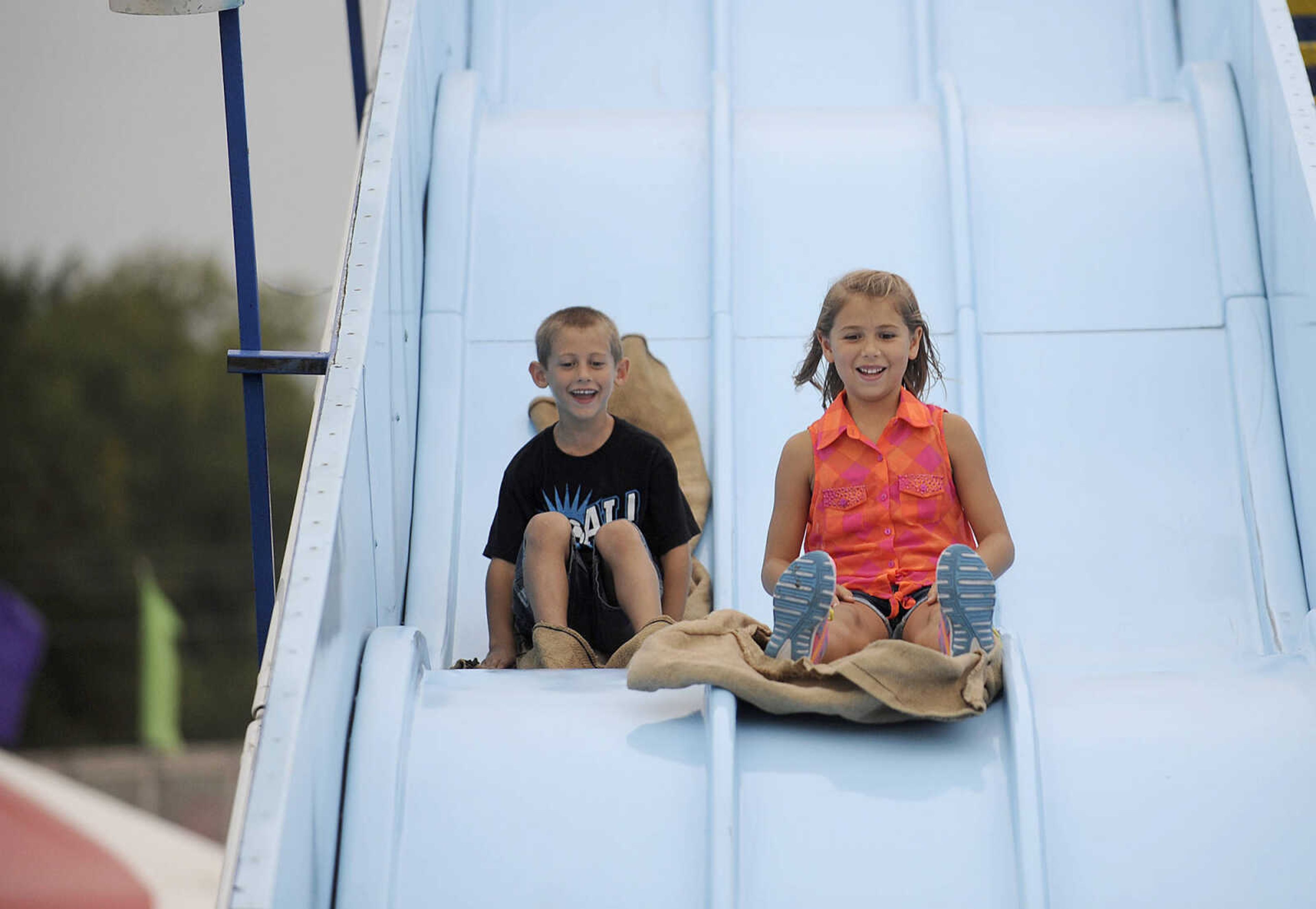 GLENN LANDBERG ~ glandberg@semissourian.com

Tate and Maci Zoellner take a ride down a giant slide during the SEMO District Fair Wednesday, Sept 10, 2014 at Arena Park in Cape Girardeau.