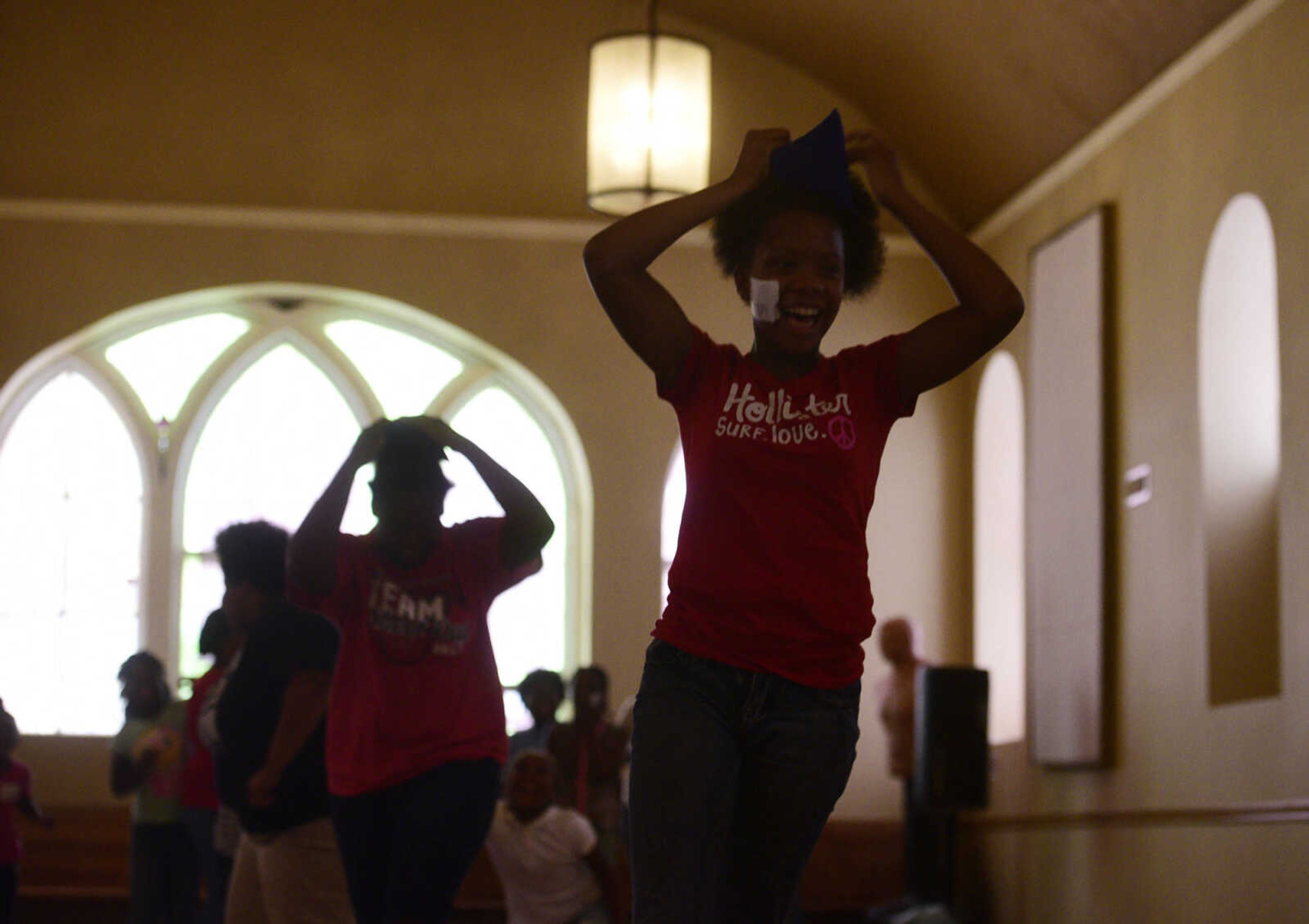 Students try to balance a small sandbag on their heads without having it slide off on Monday, Aug. 14, 2017, during the Salvation Army's after school program at The Bridge Outreach Center in Cape Girardeau.