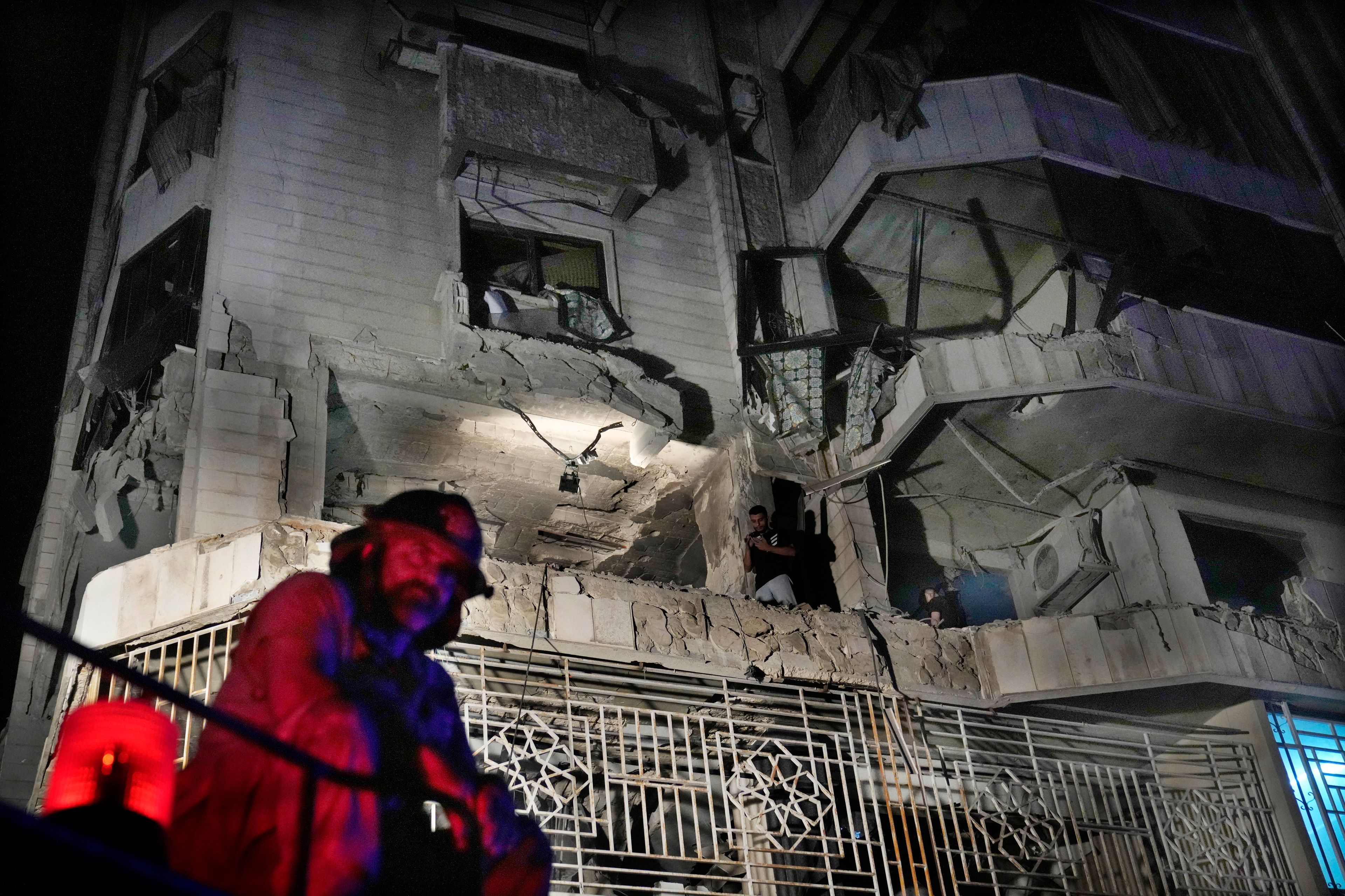 A firefighter stands in front of an apartment hit by an Israeli airstrike, in Beirut, Lebanon, Thursday, Oct. 3, 2024. (AP Photo/Hussein Malla)