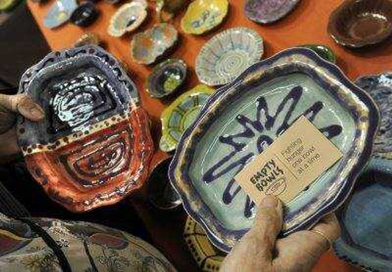 A patron selects two bowls at the ninth annual Empty Bowls Banquet on Sunday at the Salvation Army Worship and Community Center in Cape Girardeau.