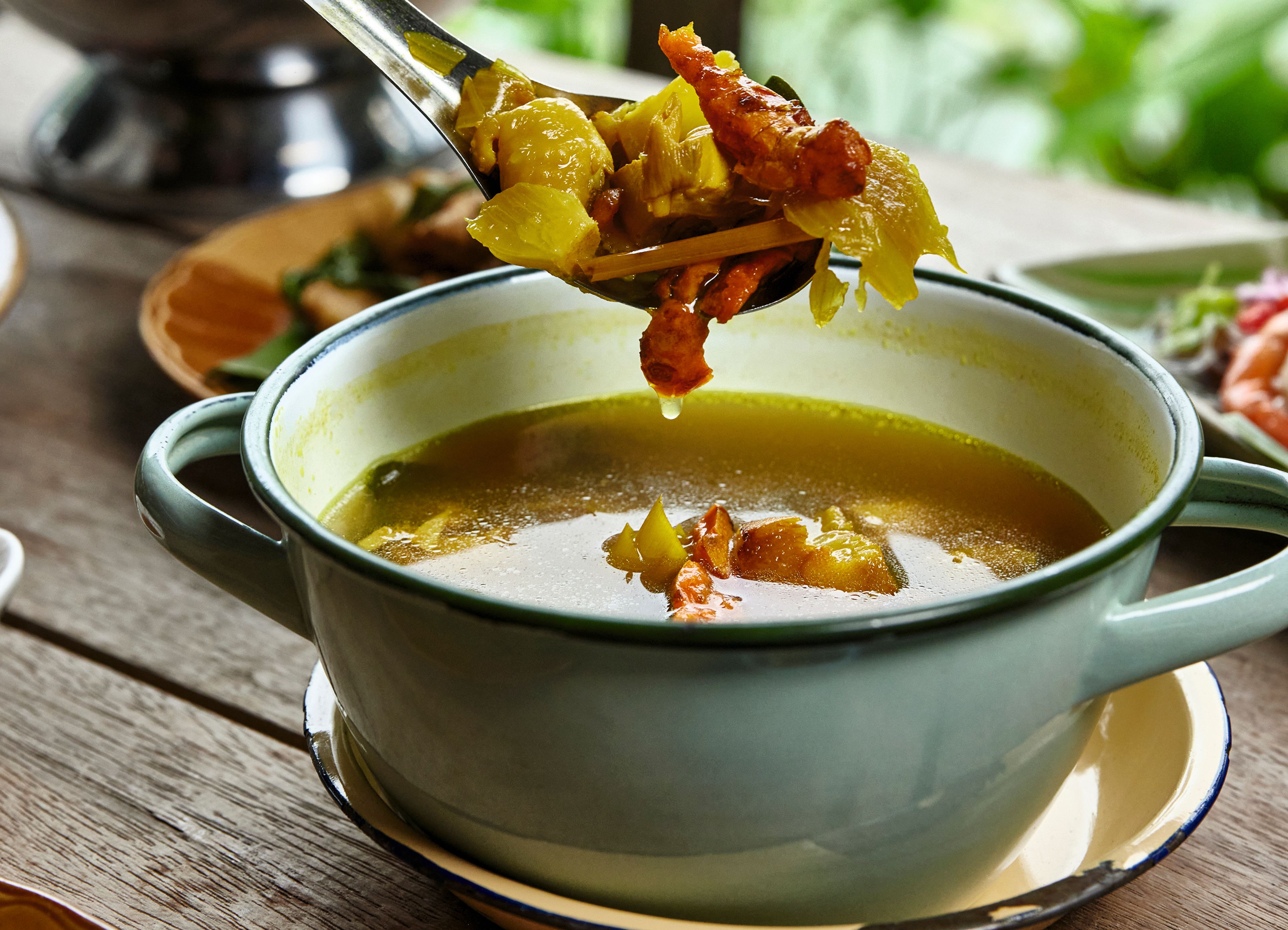 This photo shows a recipe for Gai Tom Kamin from the cookbook “Kalaya’s Southern Thai Kitchen” by Nok Suntaranon, with Natalie Jesionka.Suntaranon's turmeric chicken soup is herbaceous and heavy on aromatics, with a handful of cilantro. (Michael Persico via AP)