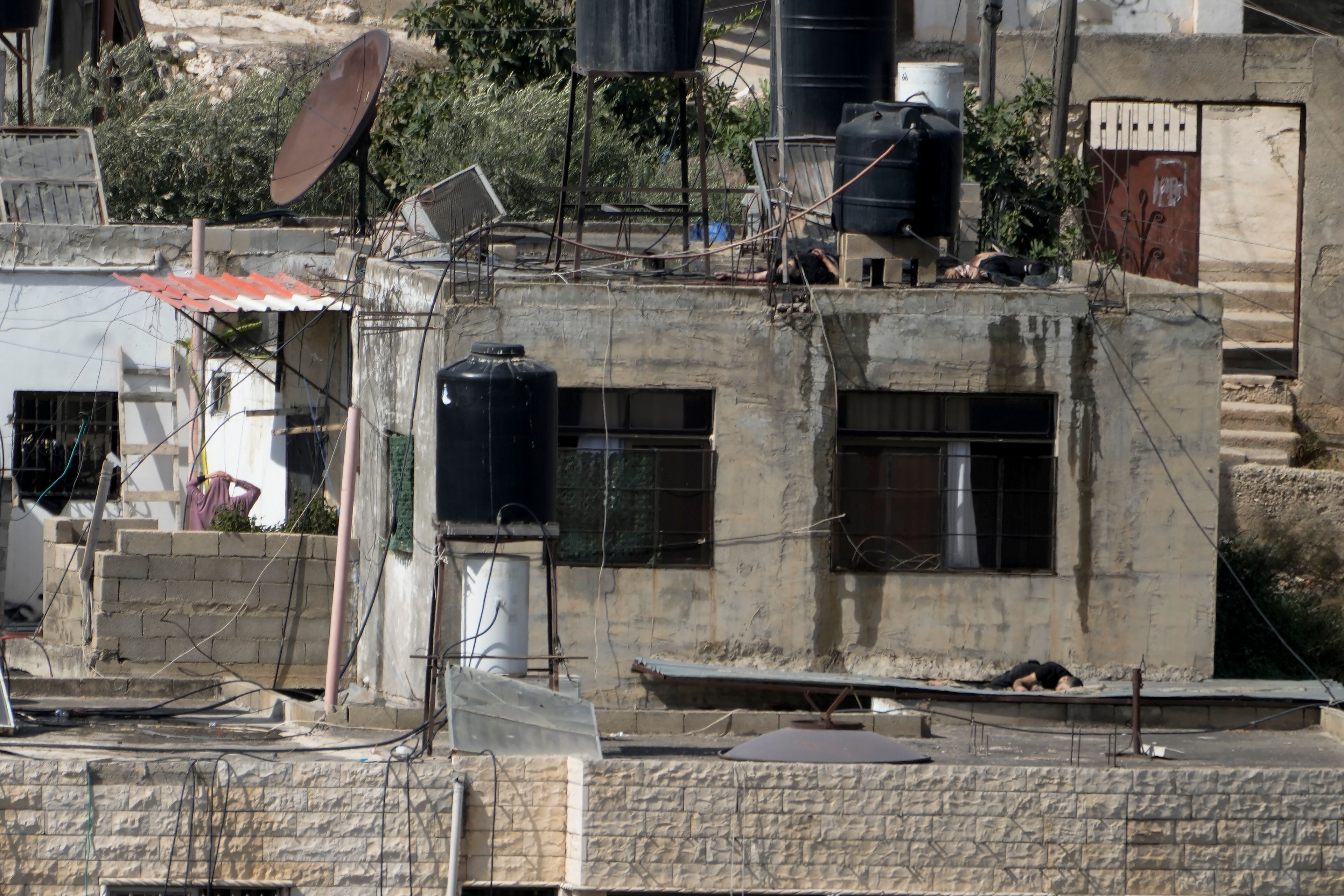 EDS NOTE: GRAPHIC CONTENT - Three bodies lie motionless on rooftops in the West Bank town of Qabatiya during a Israeli raid, Thursday, Sept. 19, 2024. (AP Photo/Majdi Mohammed)