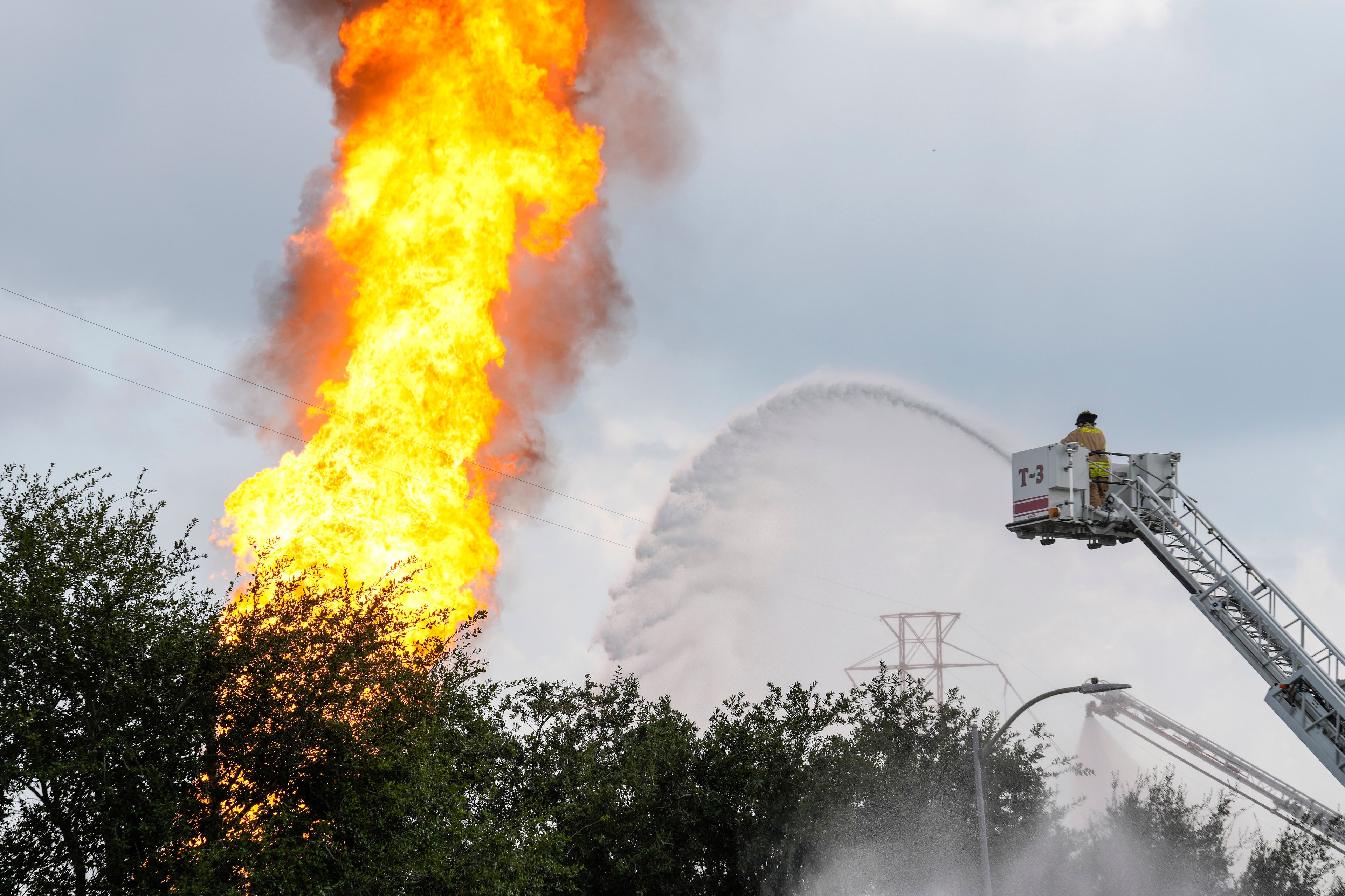 A firefighter directs a line of water around a fire on a pipeline carrying liquified natural gas near Spencer Highway and Summerton on Monday, Sept. 16, 2024, in La Porte, Texas. (Brett Coomer/Houston Chronicle via AP)