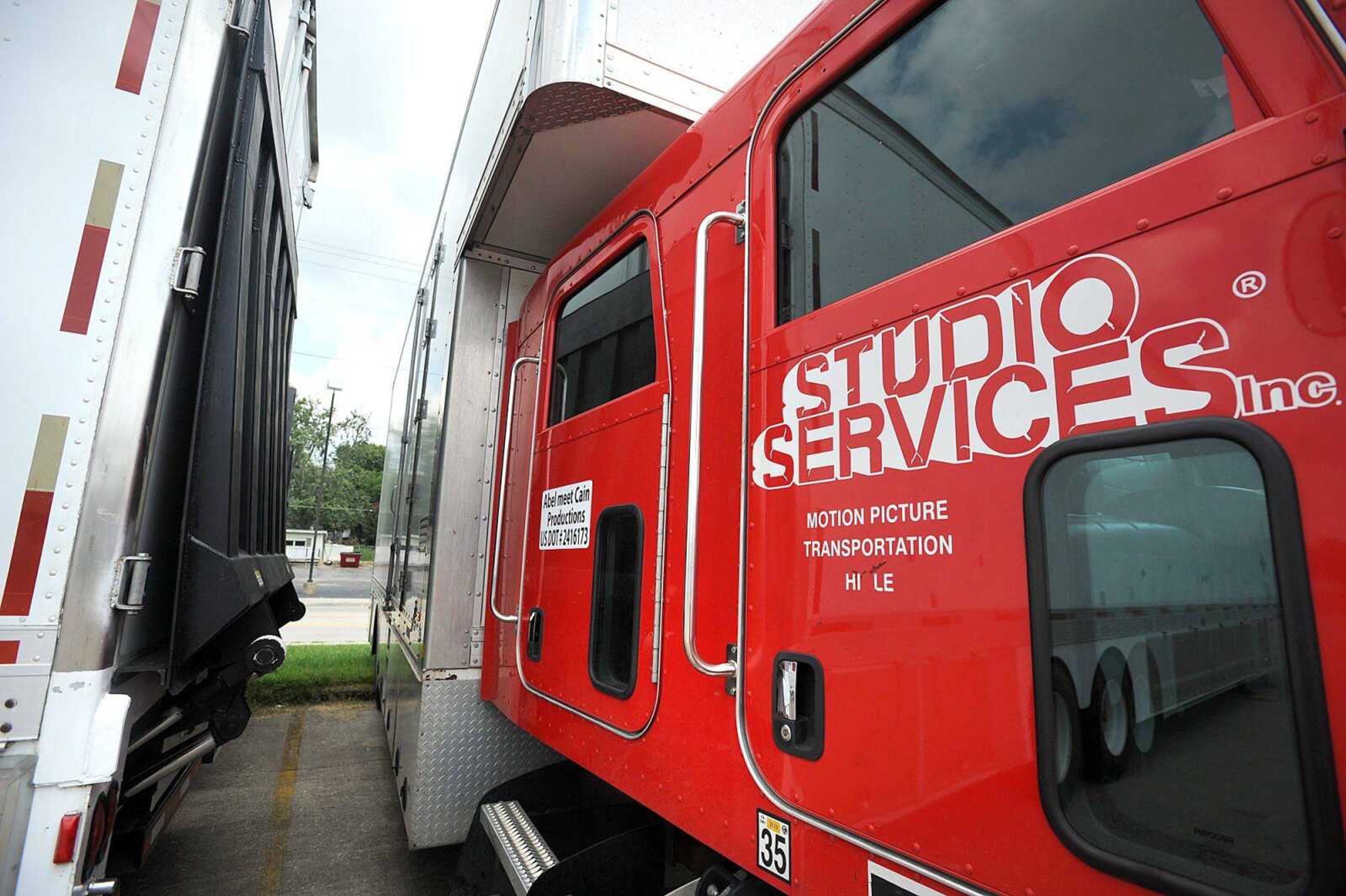 A Studio Services Inc. moving truck and Grip Nation USA trailer sit in the parking lot of the old Thorngate building on Independence Street on Monday in Cape Girardeau. Signs of the feature film &#8220;Gone Girl&#8221; being shot in Cape Girardeau have been popping up around town recently. (Laura Simon)