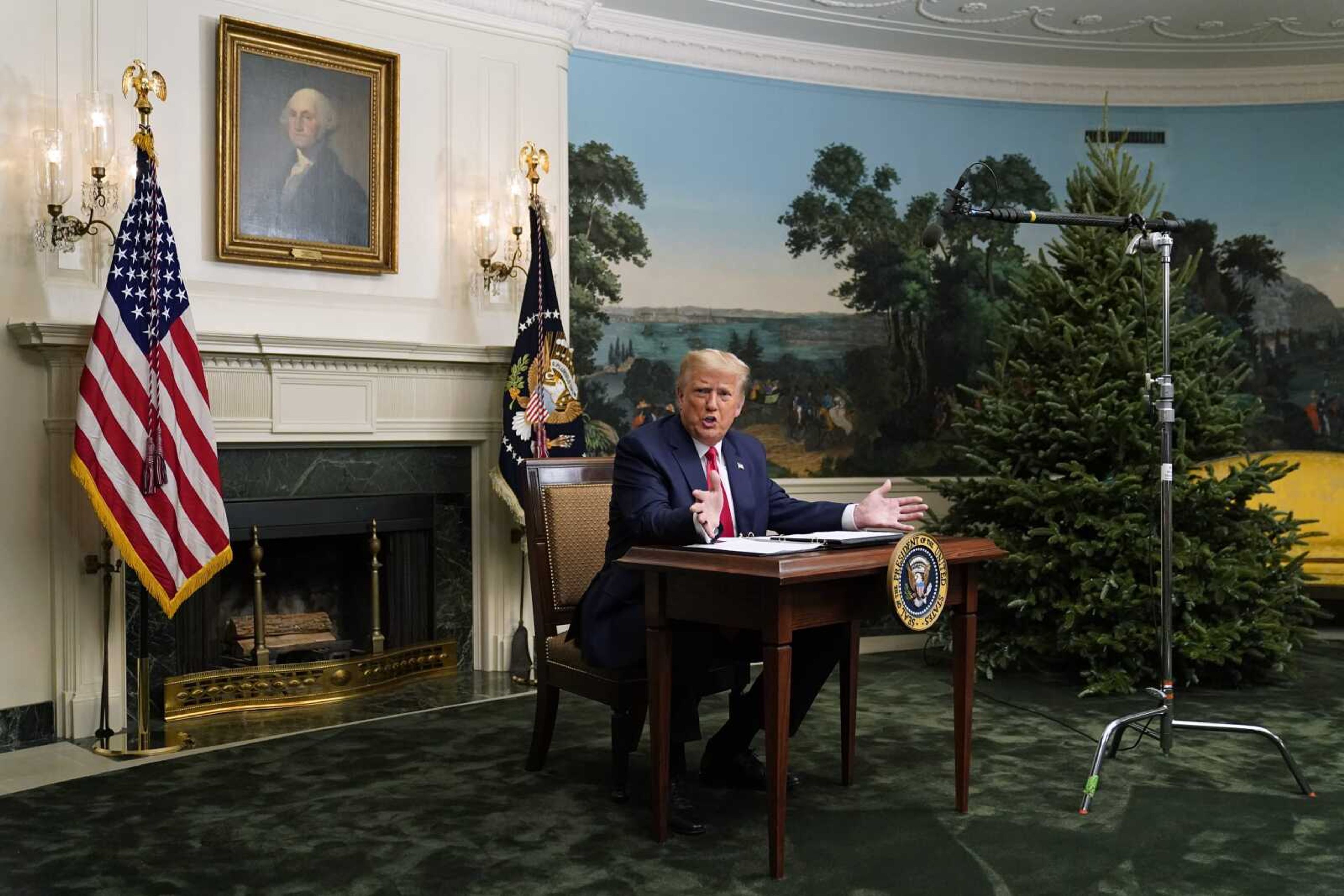 President Donald Trump speaks with reporters Thursdday after participating in a video teleconference call with members of the military on Thanksgiving at the White House in Washington.