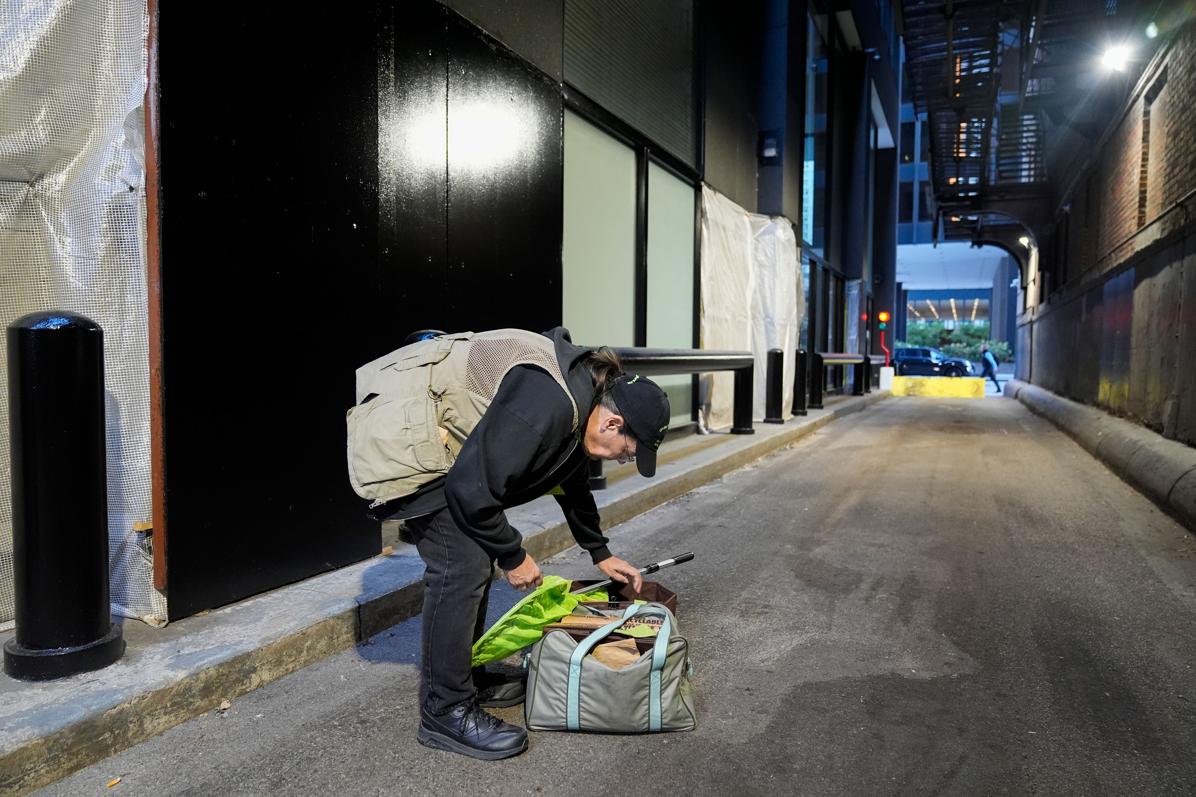 Chicago Bird Collision Monitors Director Annette Prince collects a dead white-throated sparrow, a kind of migrating bird, in an alley Tuesday, Oct. 8, 2024, in Chicago. (AP Photo/Erin Hooley)