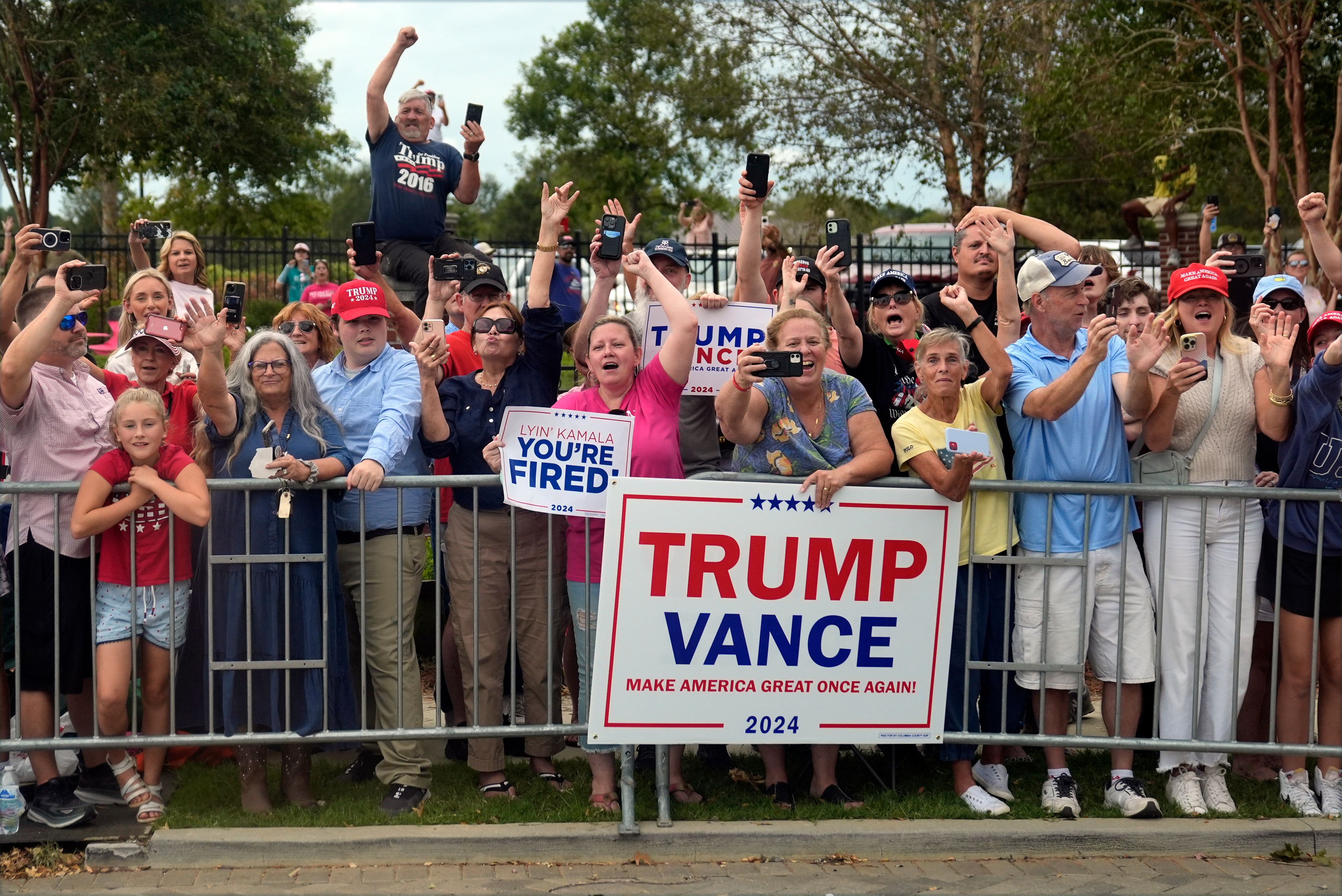 People line the road as Republican presidential nominee former President Donald Trump arrives to speak at a temporary relief shelter as he visits areas impacted by Hurricane Helene, Friday, Oct. 4, 2024, in Evans, Ga. (AP Photo/Evan Vucci)