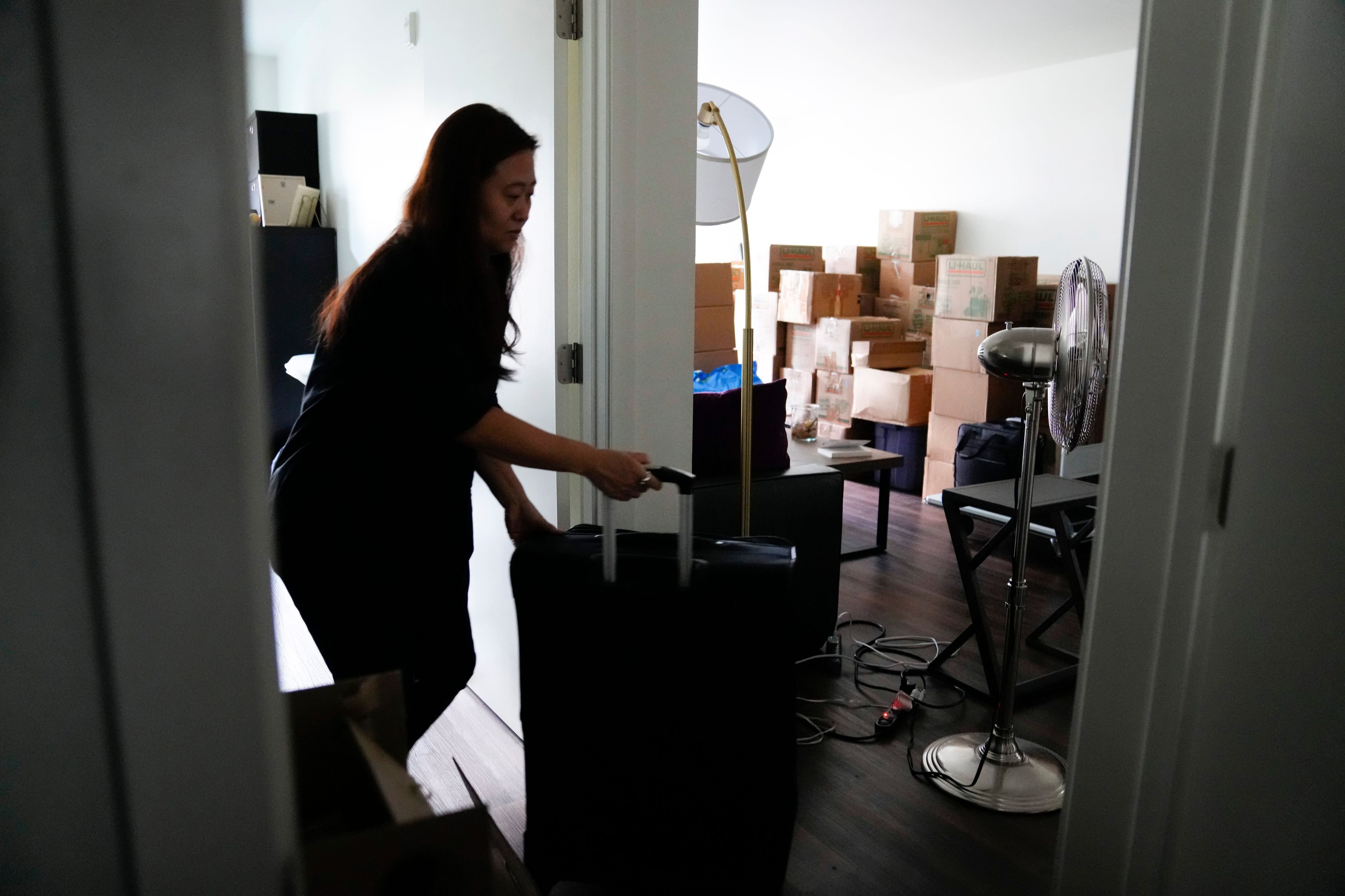 Adoptee Rebecca Kimmel wheels her luggage through her apartment as she prepares for her flight to South Korea to investigate her identity story, Sunday, July 2, 2023, in Seattle. In 2017, Kimmel went to a three-day event in San Francisco with hundreds of Korean adoptees and the new ideas and friendships prompted a deep sense of urgency. (AP Photo/Lindsey Wasson)