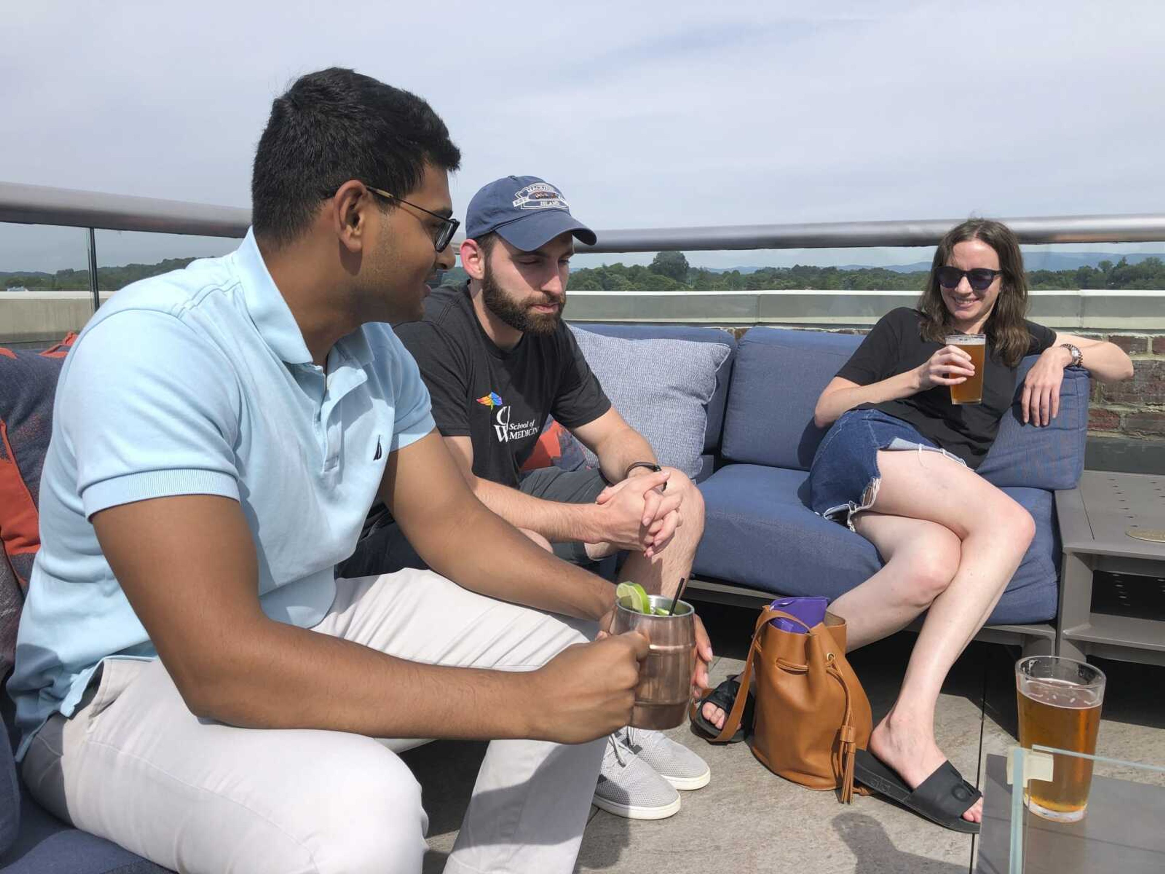 Ashish Bibireddy, 23, Floyd Kenney, 27, and Kyrra Engle speak at the rooftop bar at The Bristol Hotel in Bristol, Virginia. Ten medical students were on a tour of the city organized by a medical school with the aim of luring them to practice in rural communities facing health care shortages after graduation.