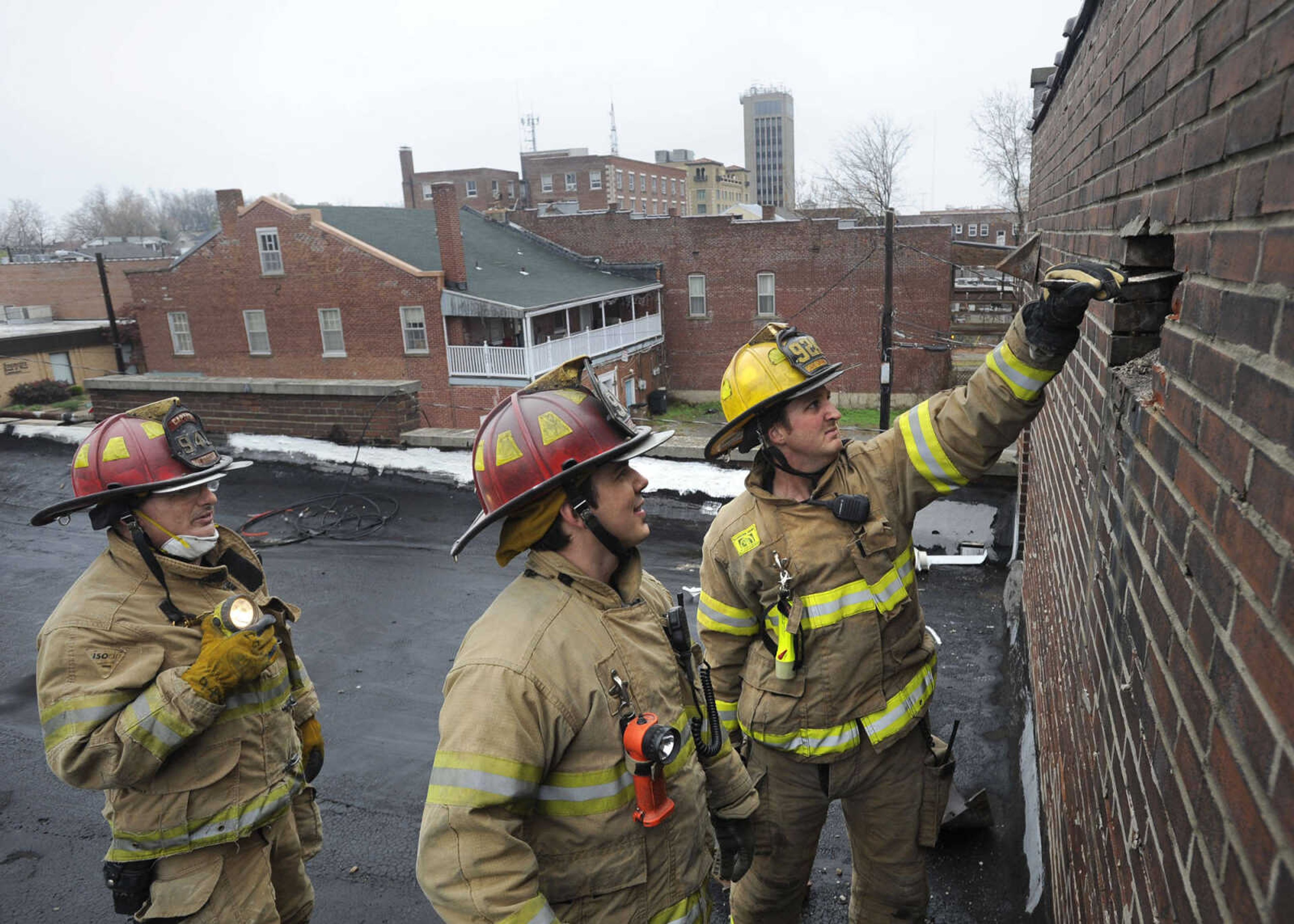 Capt. John Ryan, left, Capt. Randy Morris Jr. and firefighter Nick Moore examine a brick wall outside the old building.