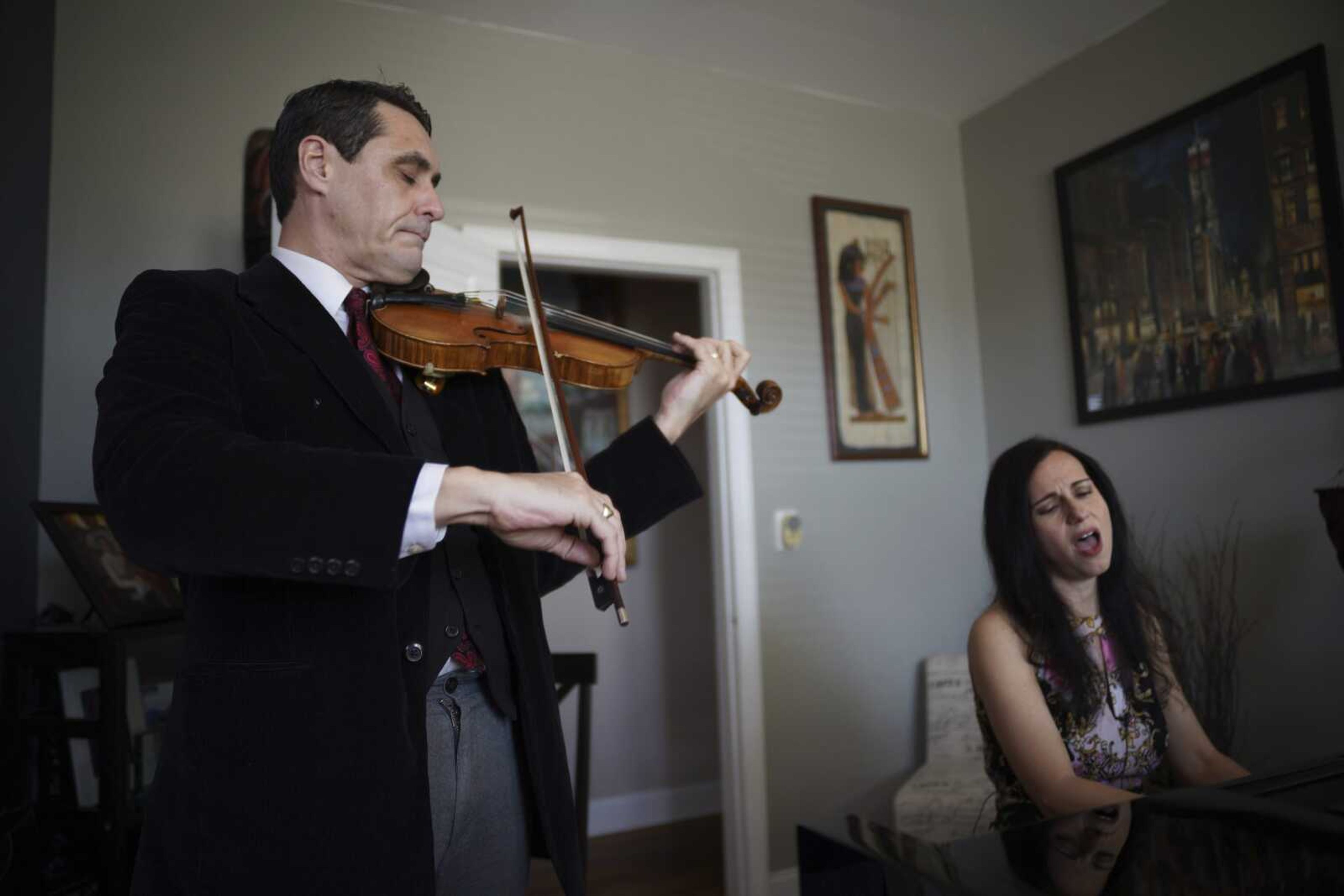 Musicians David Shenton and Erin Shields perform inside their home March 30 in the Queens borough of New York.