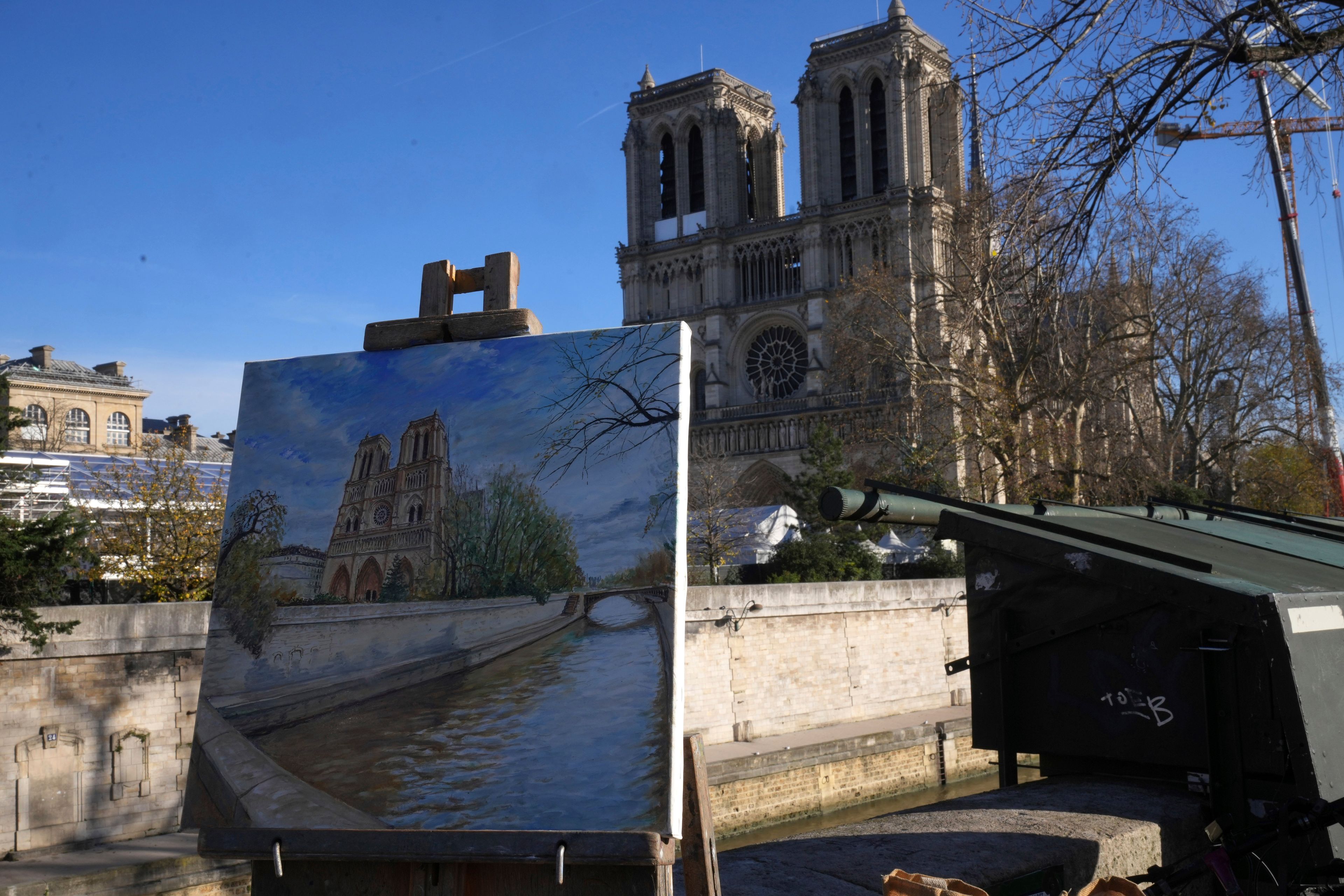 A painting showing Notre-Dame cathedral is seen along the Seine river bank, Thursday, Nov. 28, 2024 in Paris. (AP Photo/Michel Euler)