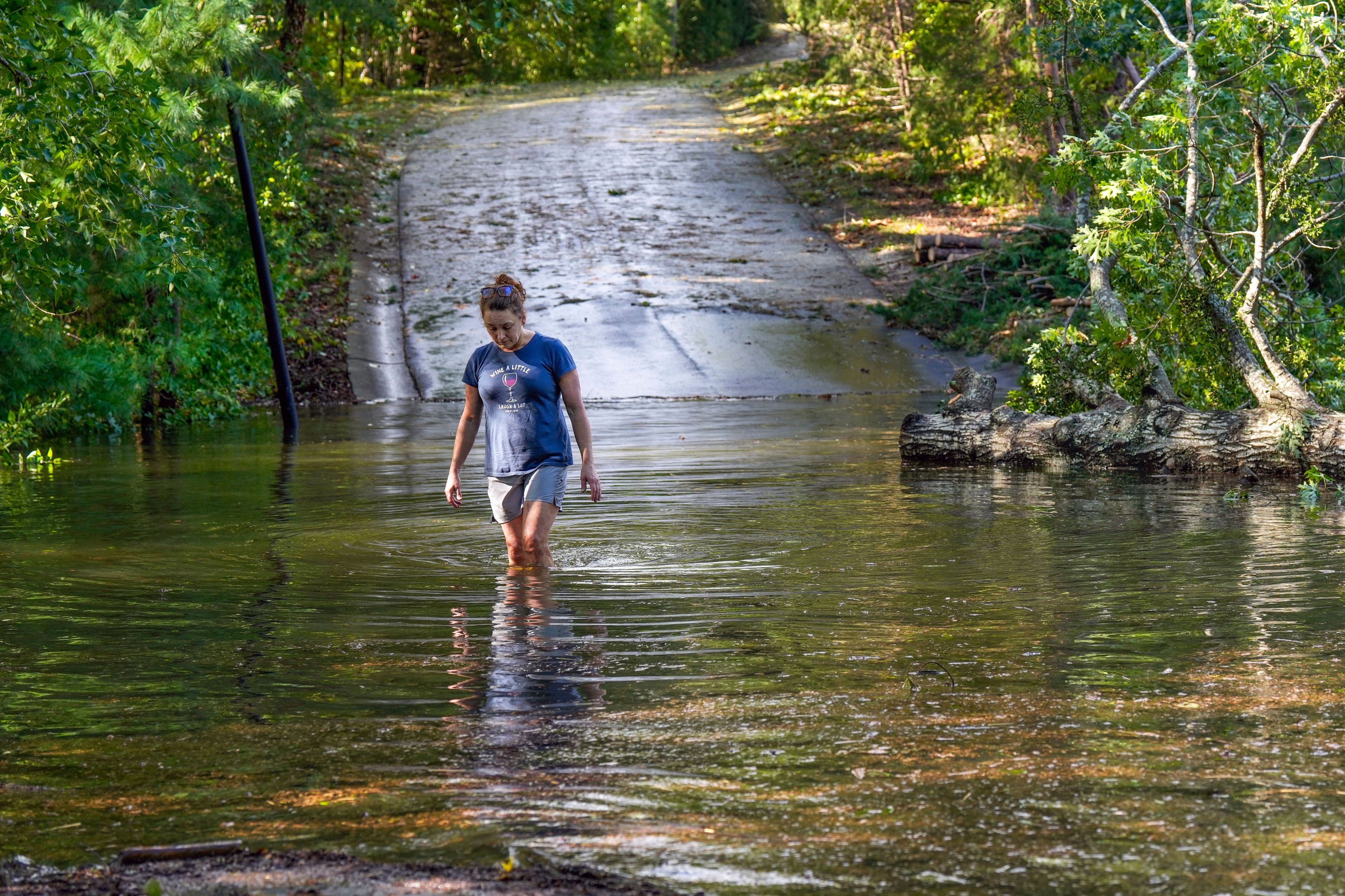 FILE - Teresa Elder walks through a flooded Sandy Cove Drive from Hurricane Helene, Sept. 27, 2024, in Morganton, N.C. (AP Photo/Kathy Kmonicek, File)